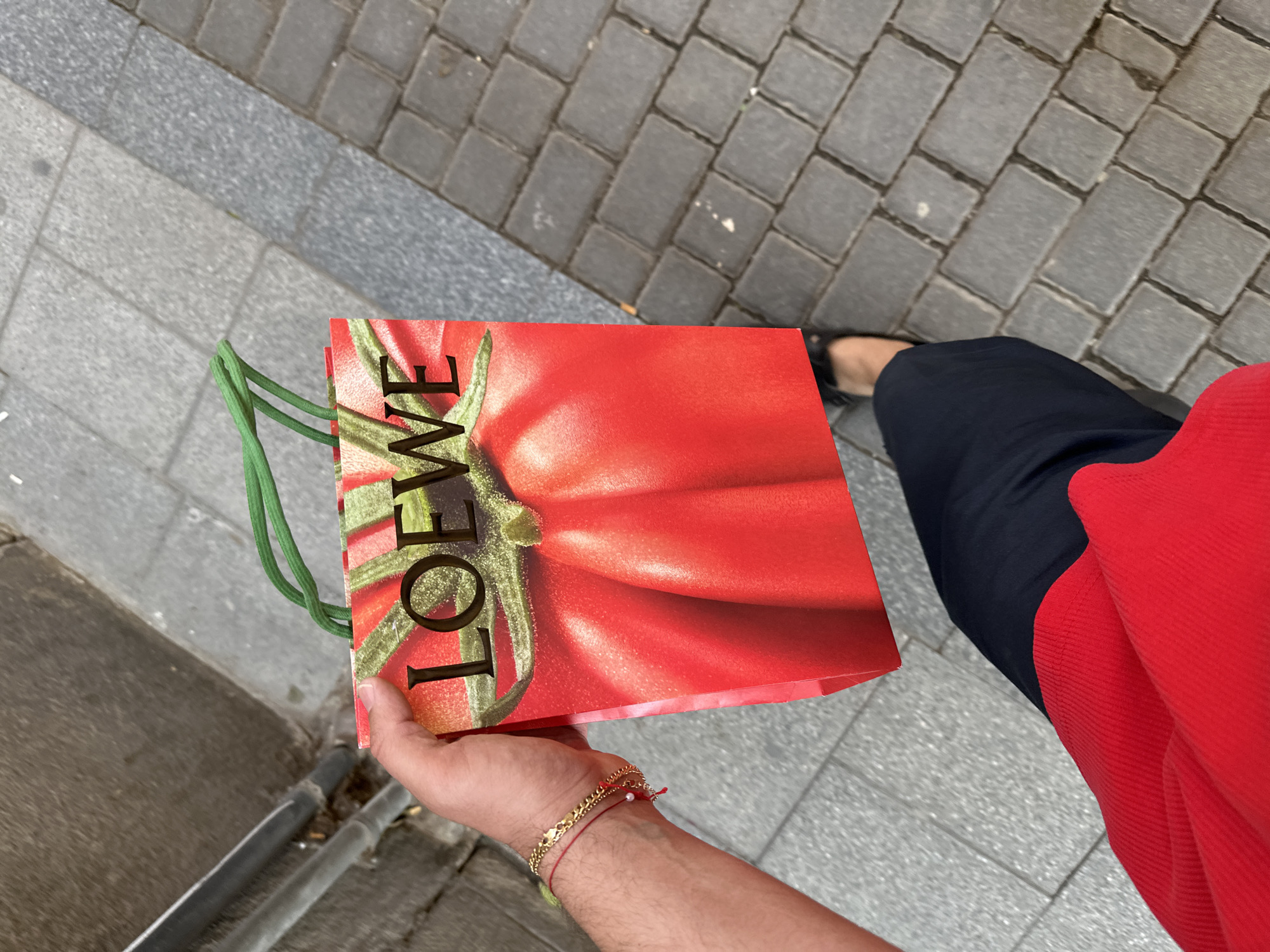 Shopper carries designer tomato-print bag through Madrid streets