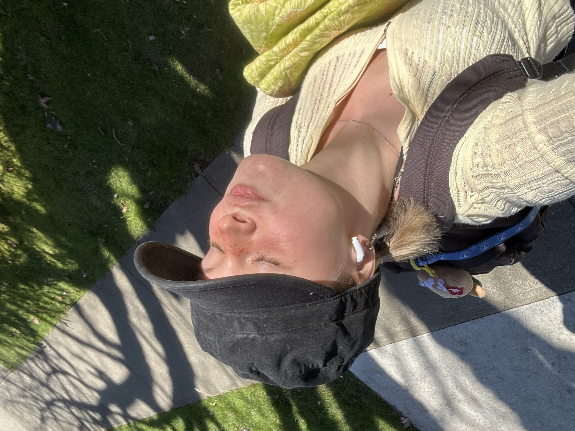 Woman rests on Vancouver sidewalk in evening sunlight