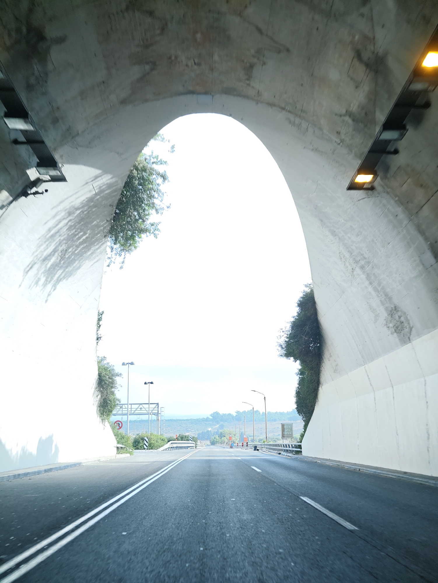 Inside a concrete tunnel opening onto sunlit Israeli countryside
