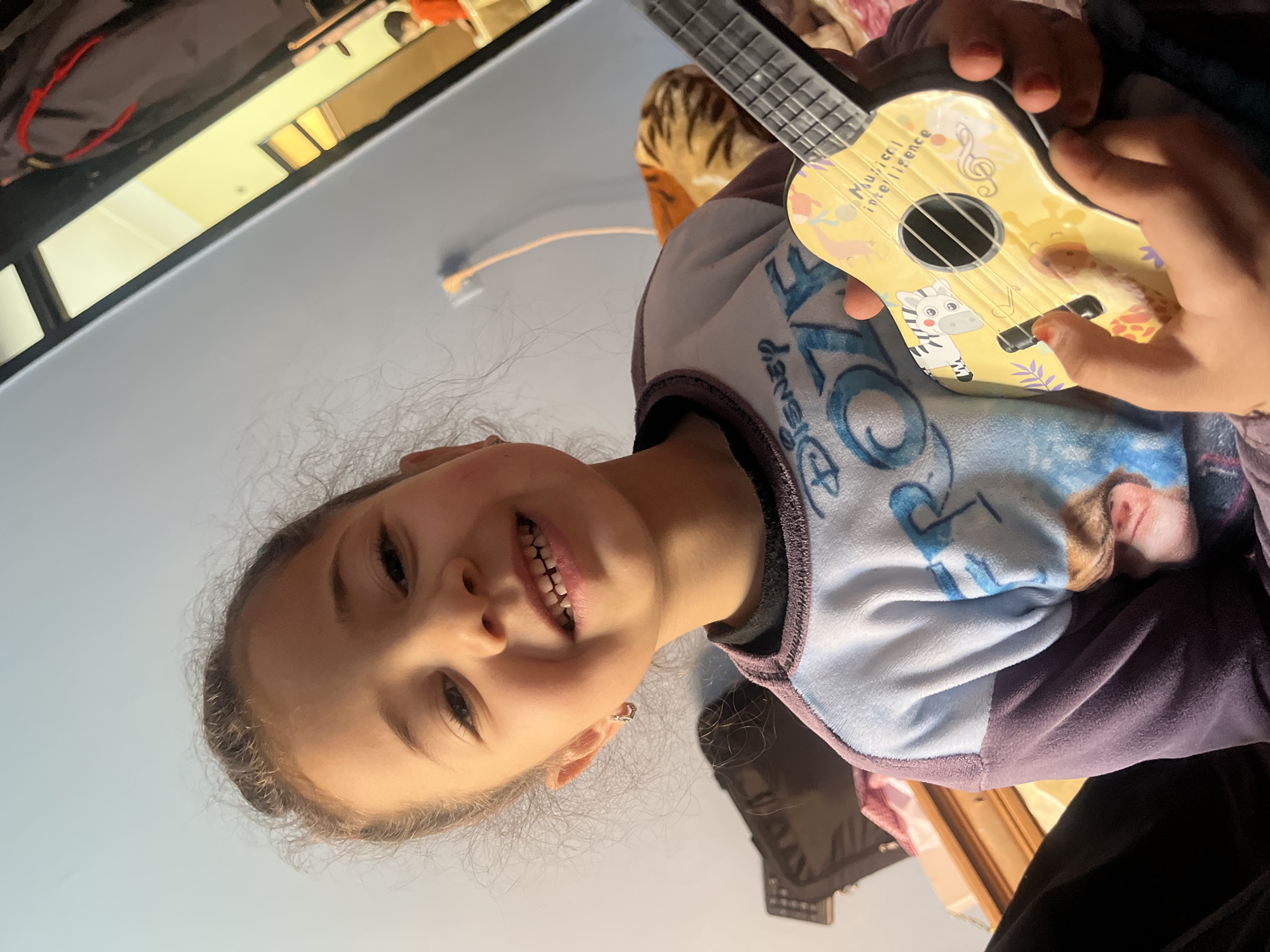 Young girl poses with toy ukulele in Morocco