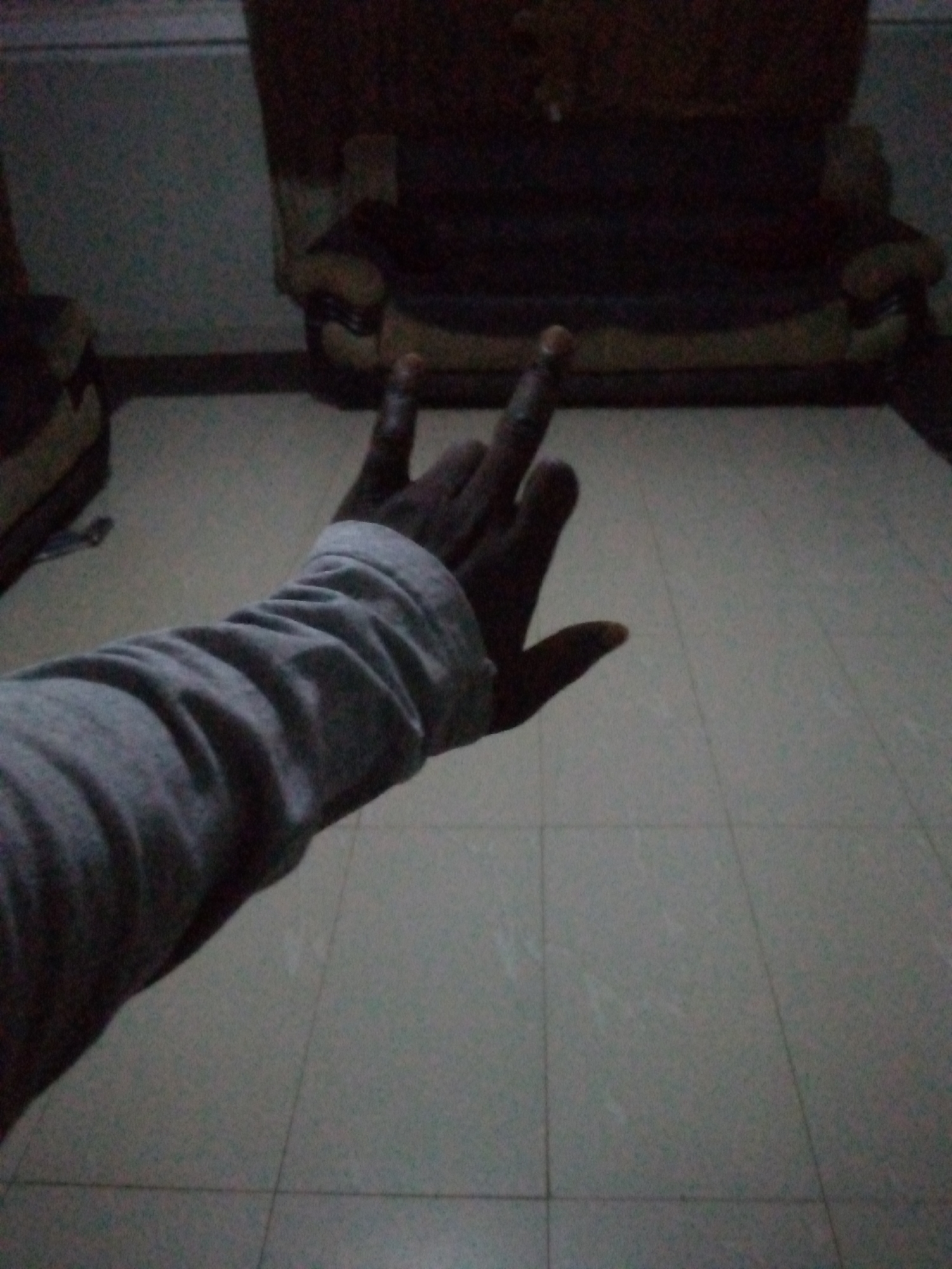 Person makes gestures, takes selfies in dim interior