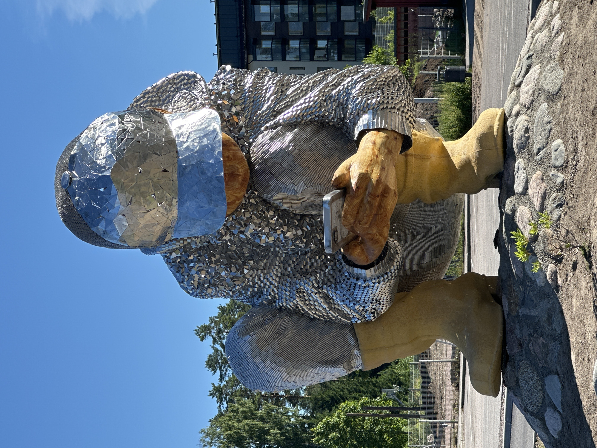 Paired squatting sculptures, metal and wood, in Tuusula public space