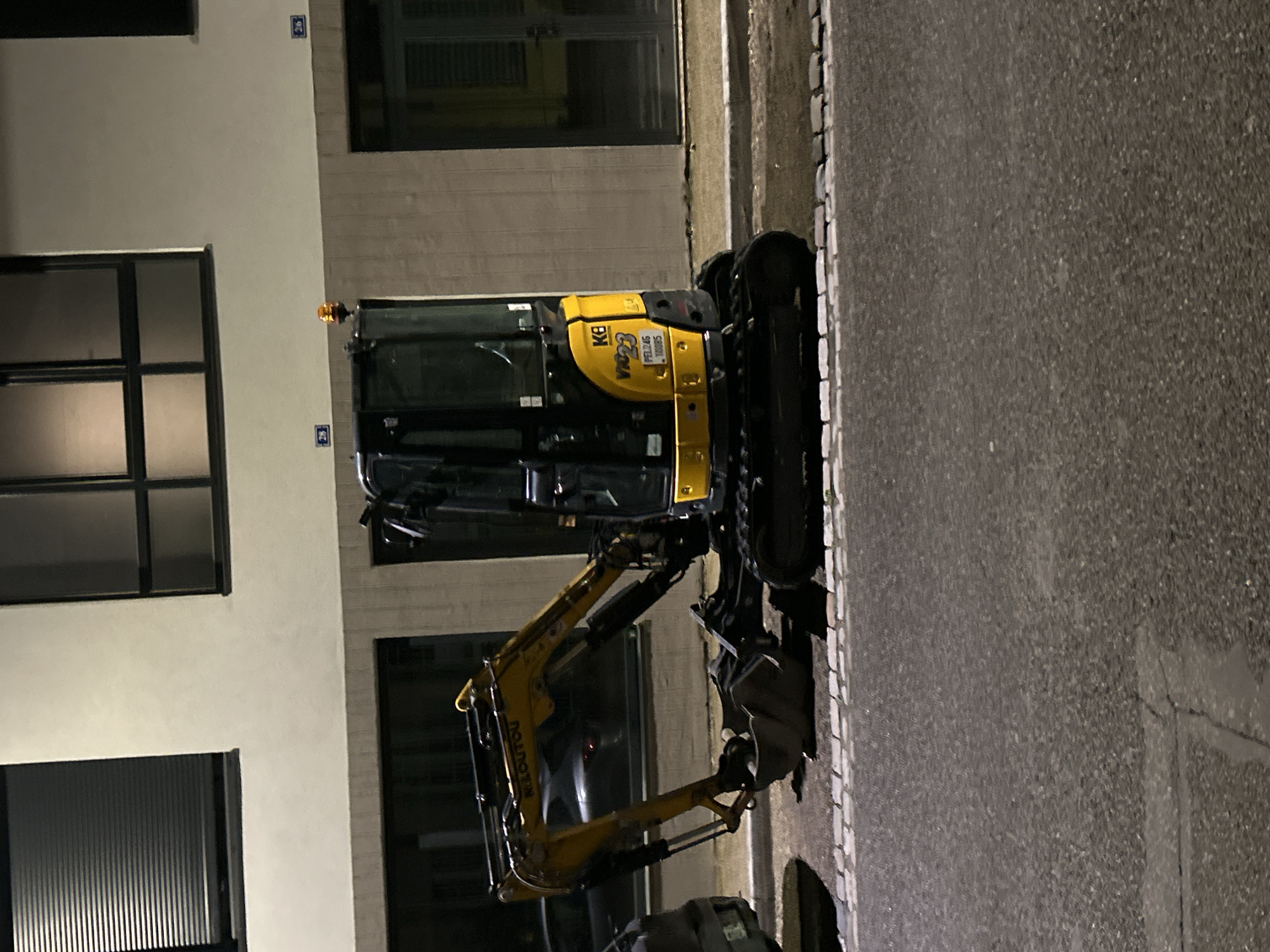 Nighttime street activity documented in Strasbourg with excavator, pedestrians