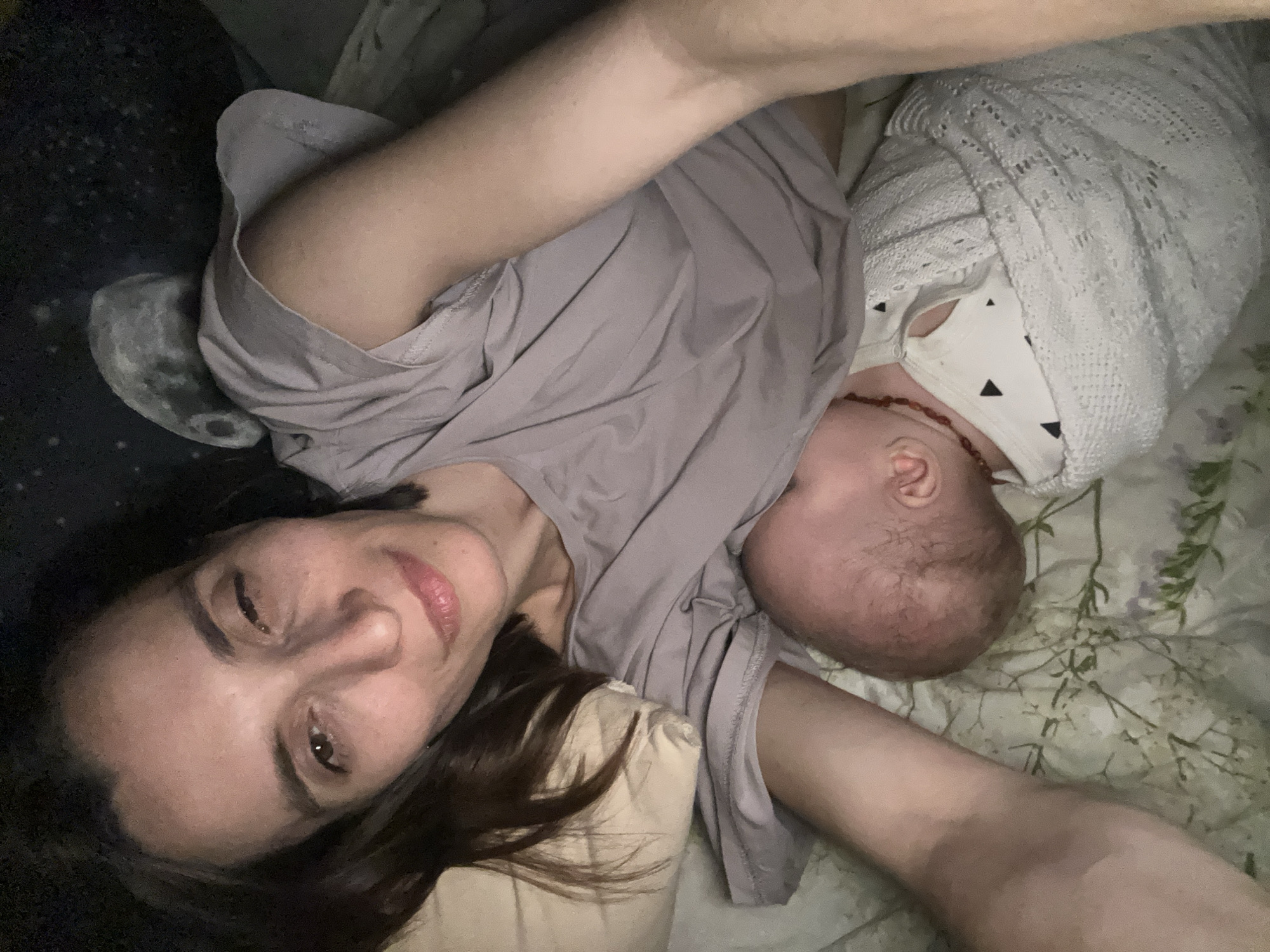 Mother and baby rest together on bed in Moscow
