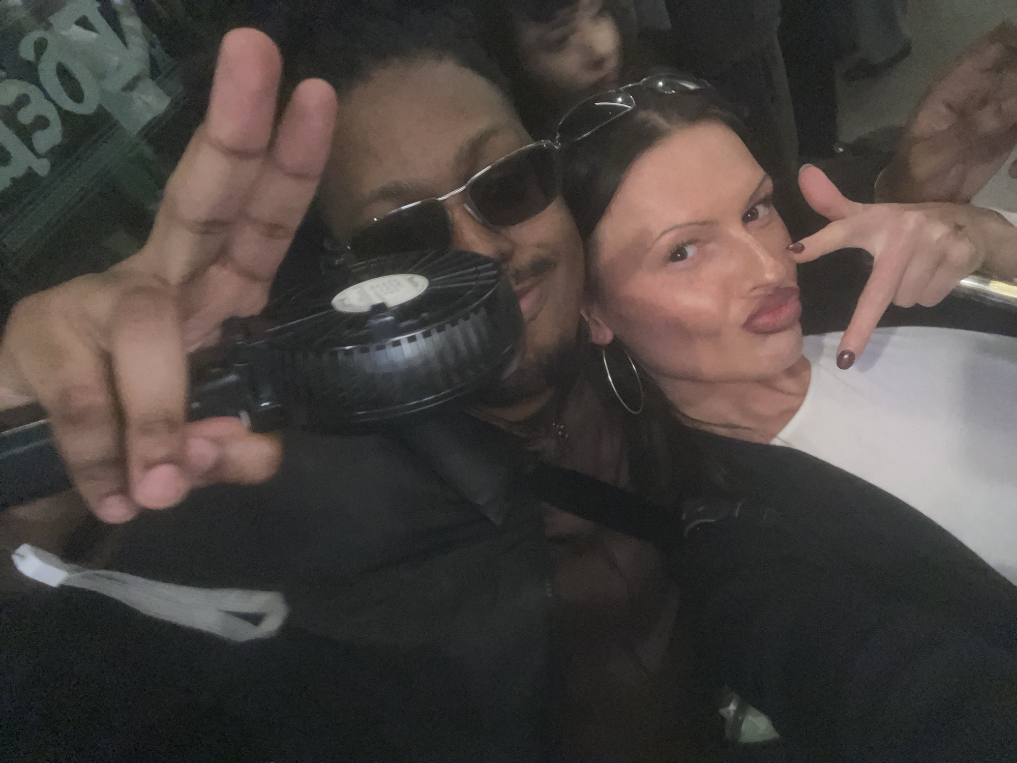 Three adults captured in dim selfie photo