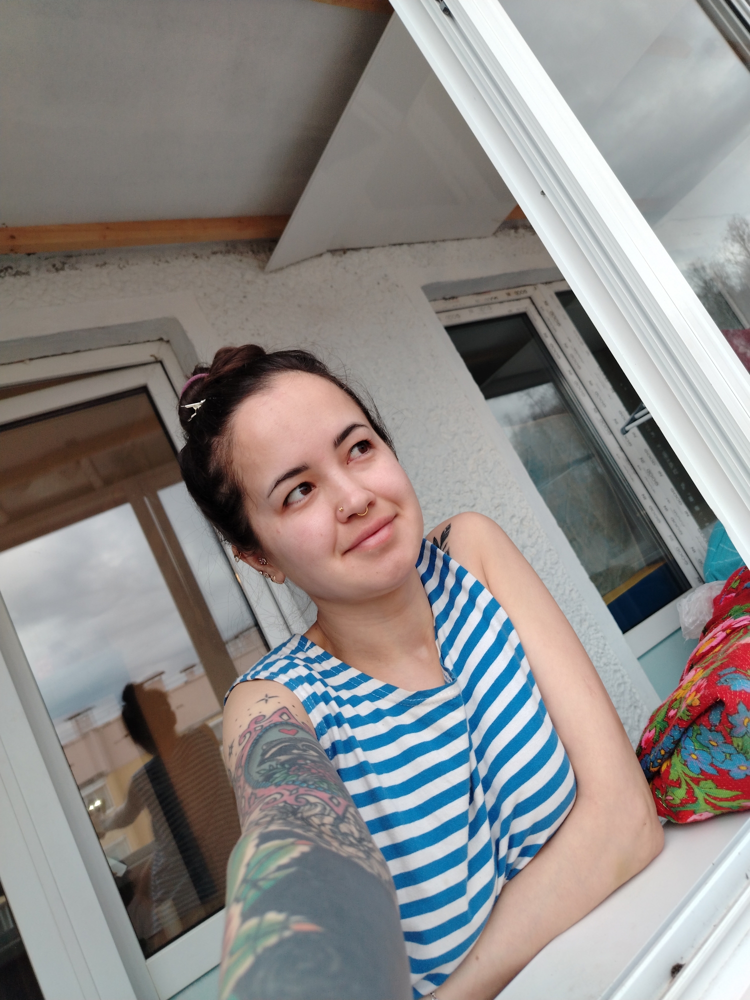 Tattooed woman observed by window in Noviy, Russia