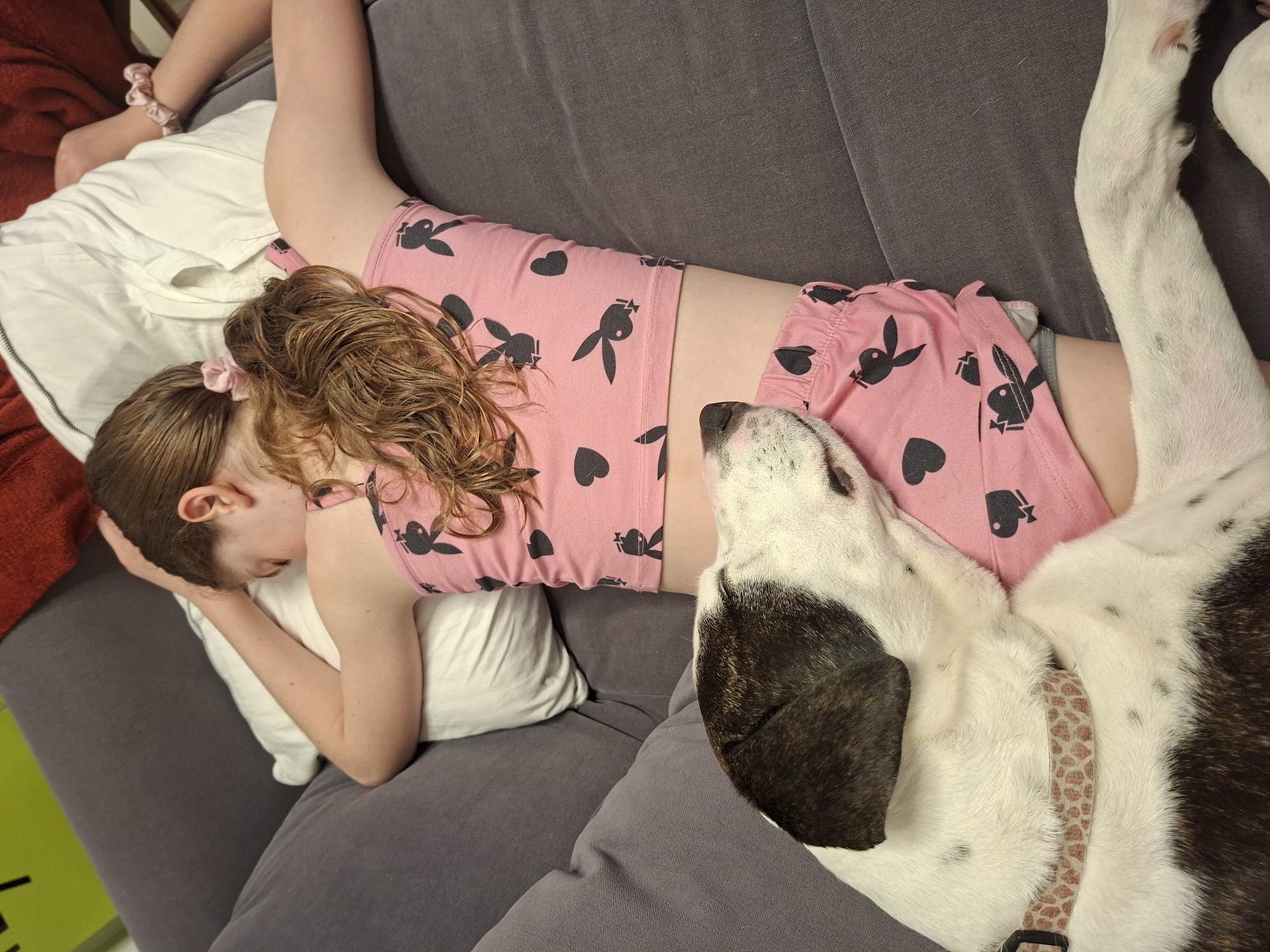 Person rests on couch in pink pajamas, Givatayim