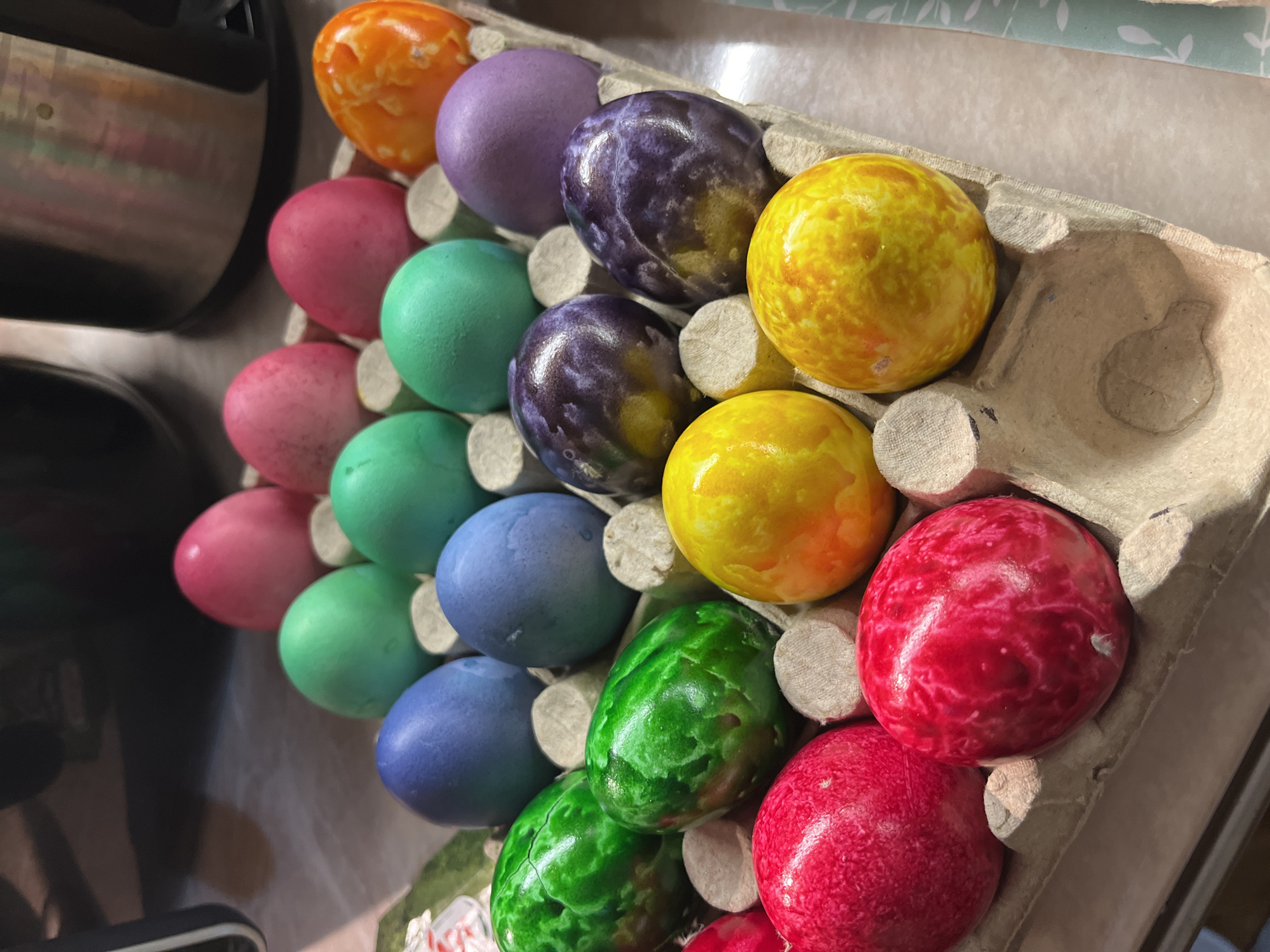 Colorful marbled Easter eggs displayed in cardboard carton