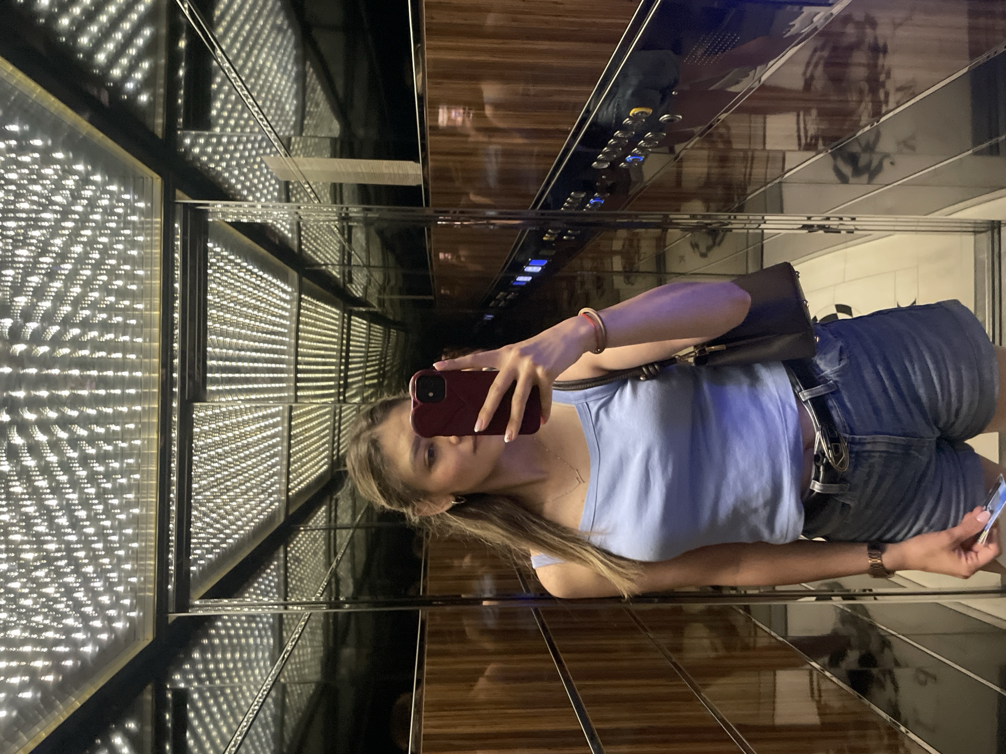 Woman takes elevator selfie, displays French manicured nails