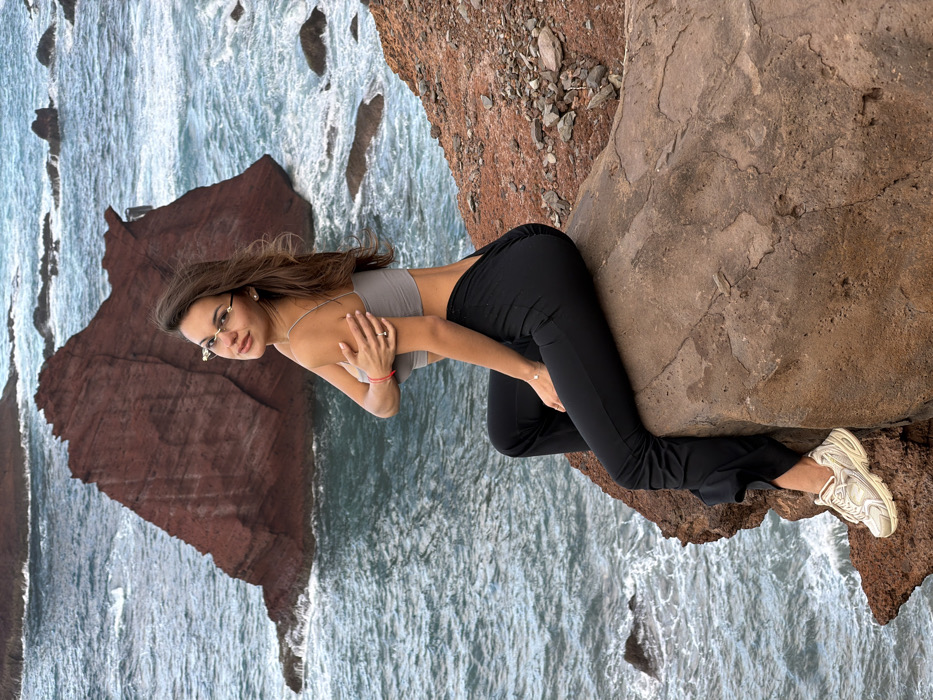 Couple photographs coastal cliffs in Machico, Portugal during evening visit