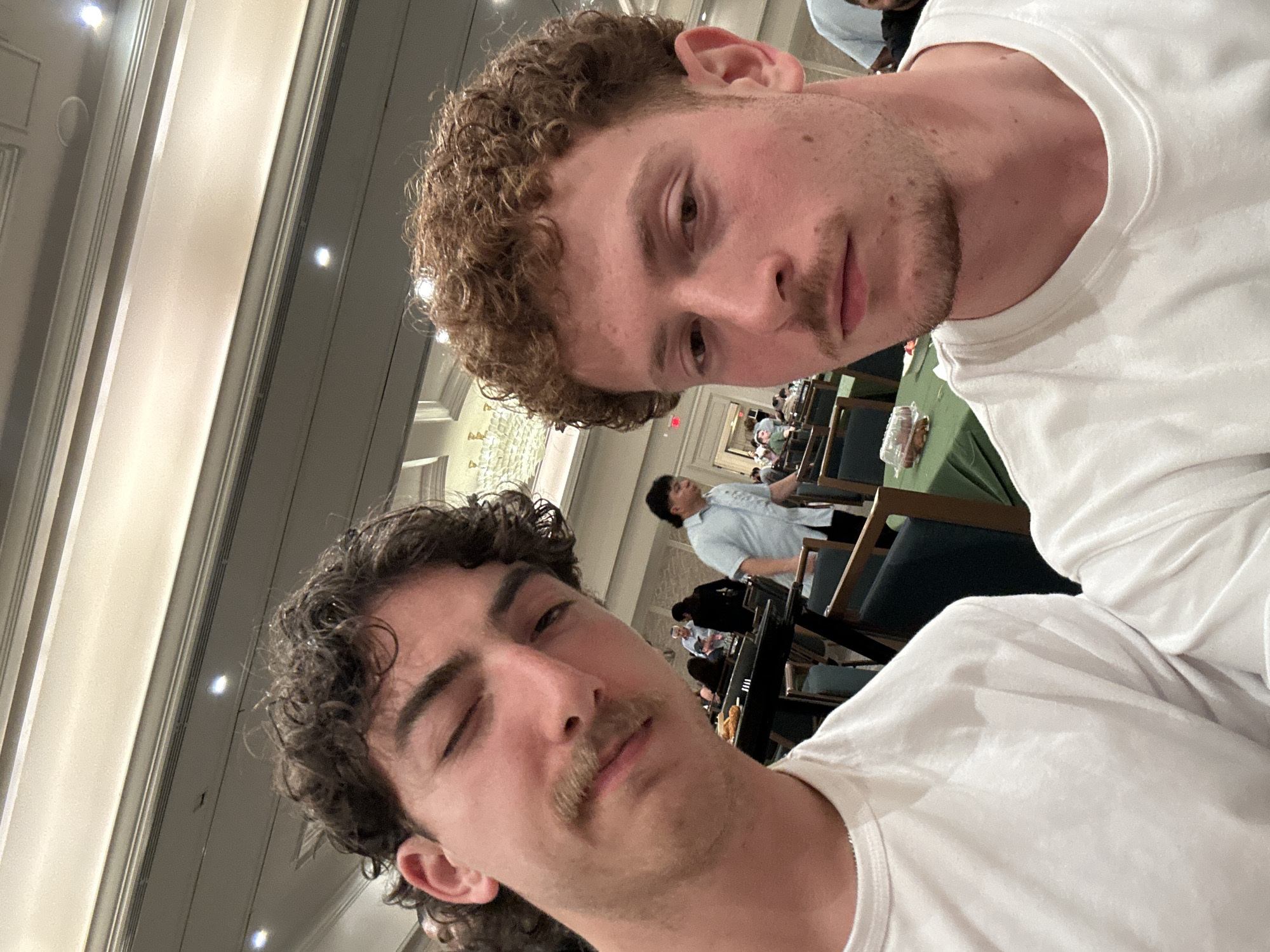 Two men take selfies indoors in Aventura