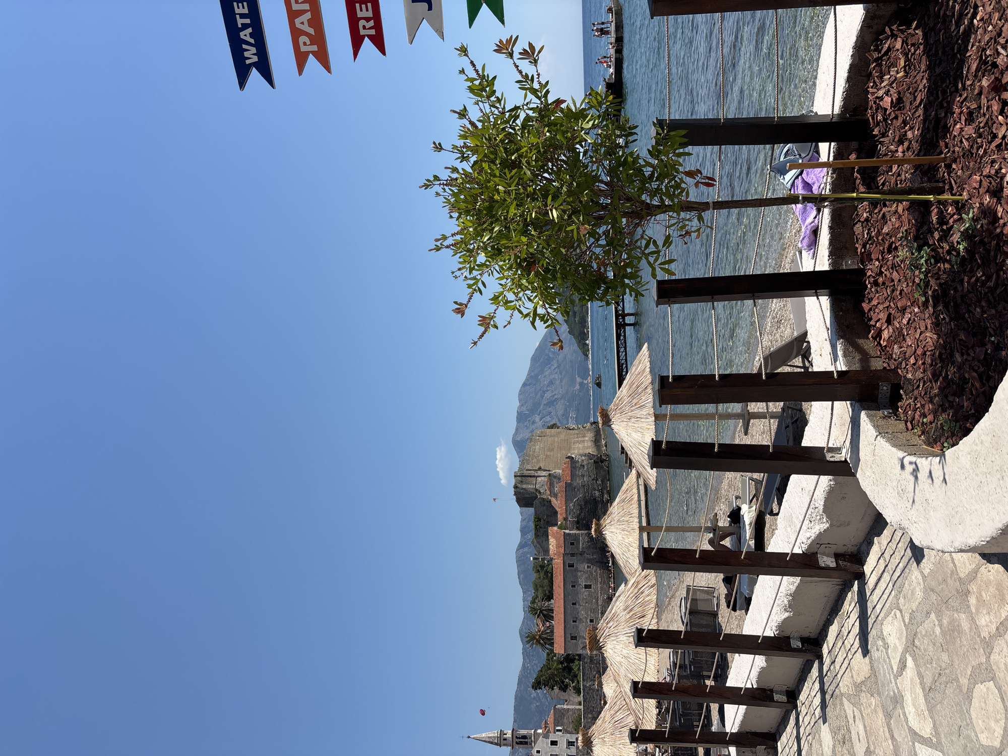 Rocky Mediterranean coastline with beaches, statues, and clifftop paths