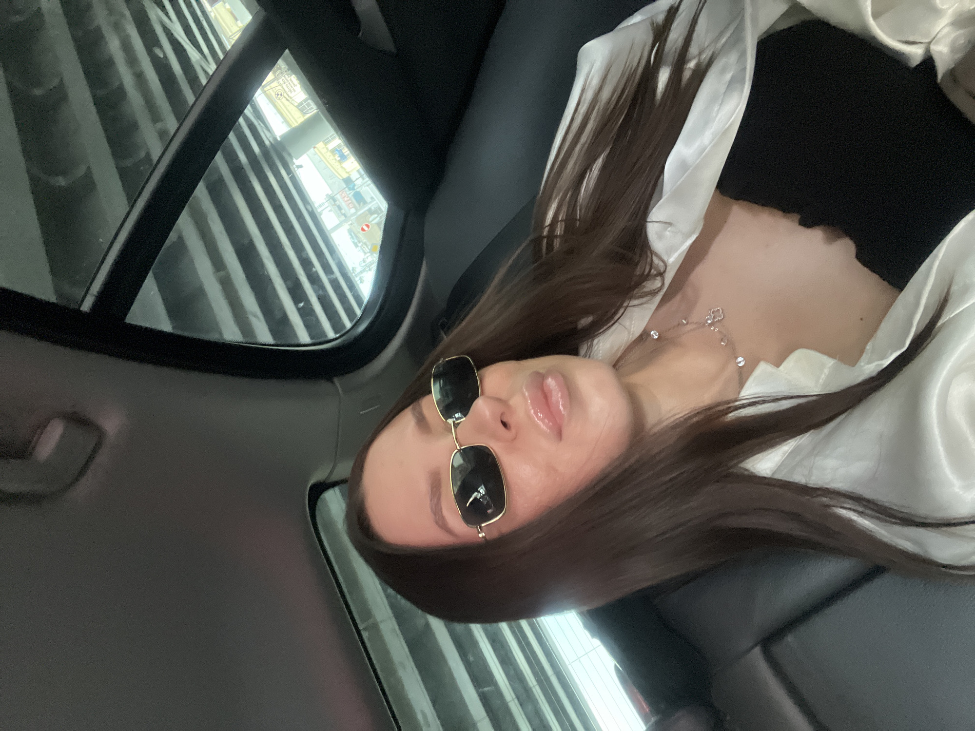 Woman in sunglasses observed in car backseat, Moscow