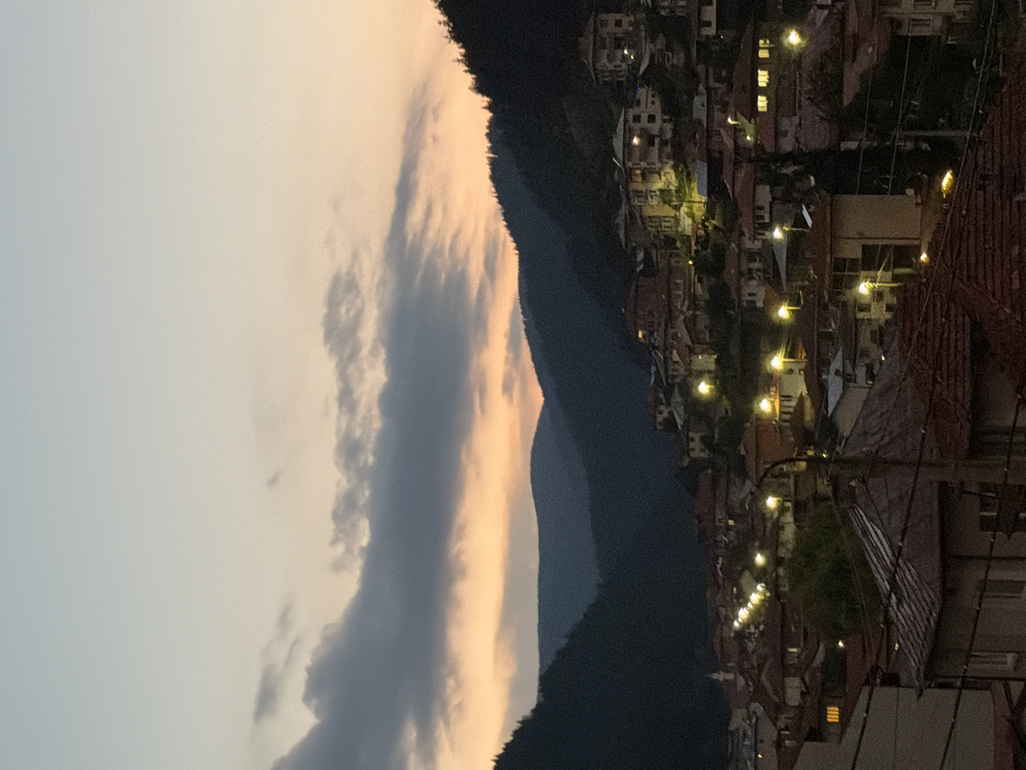 Hillside town silhouetted against a dusky orange sunset