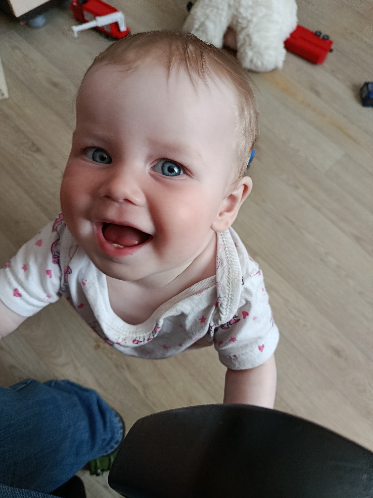 Baby in heart-patterned onesie photographed smiling