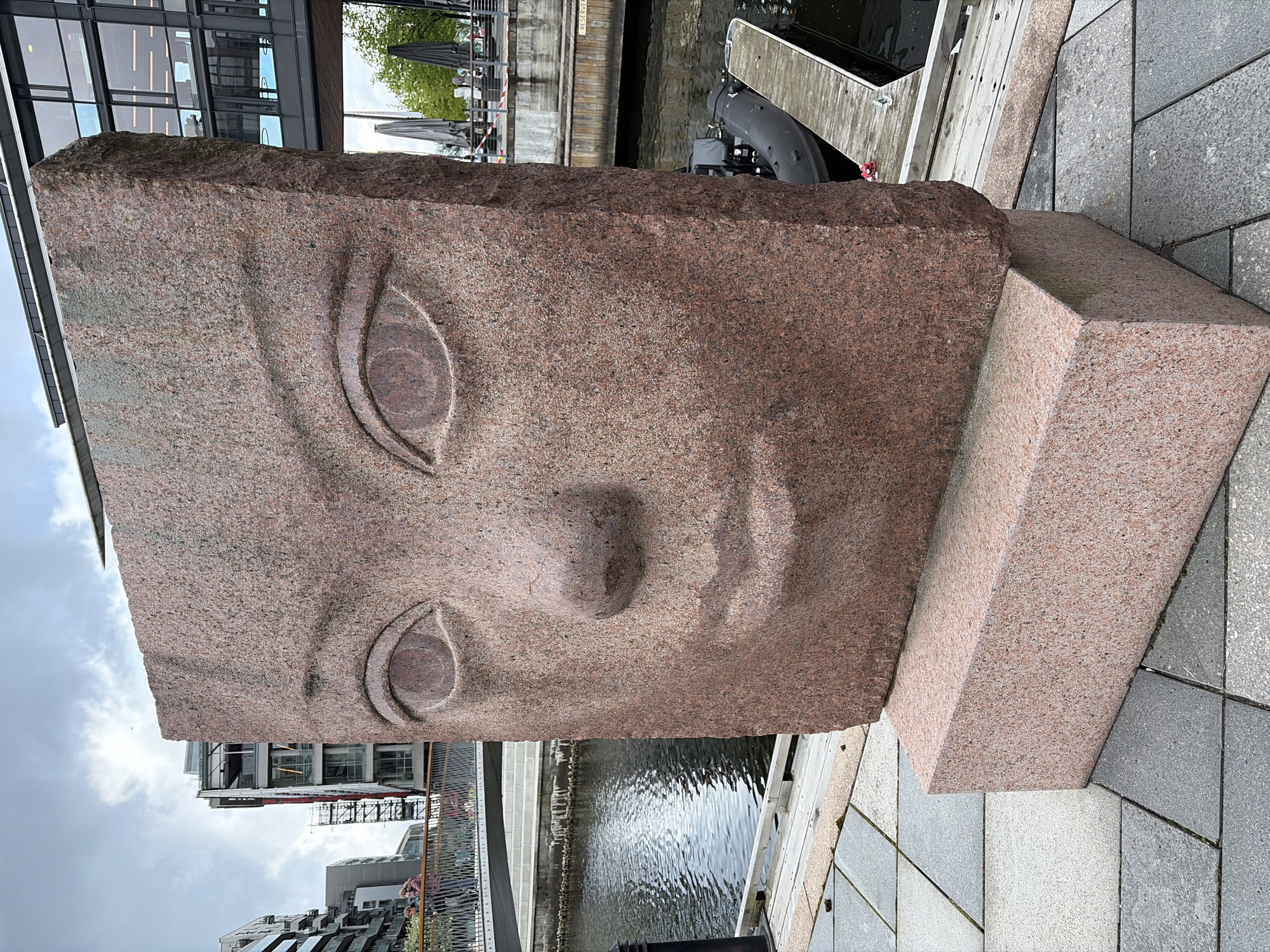 Red granite face sculpture observed in Oslo