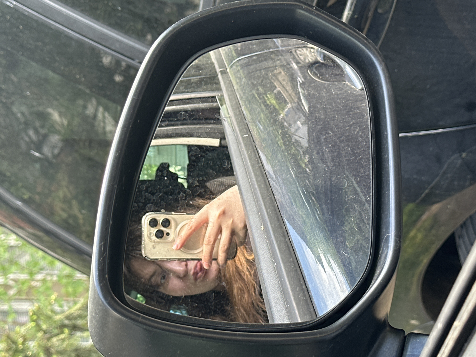 Person takes creative selfie using car mirror in Bulgaria