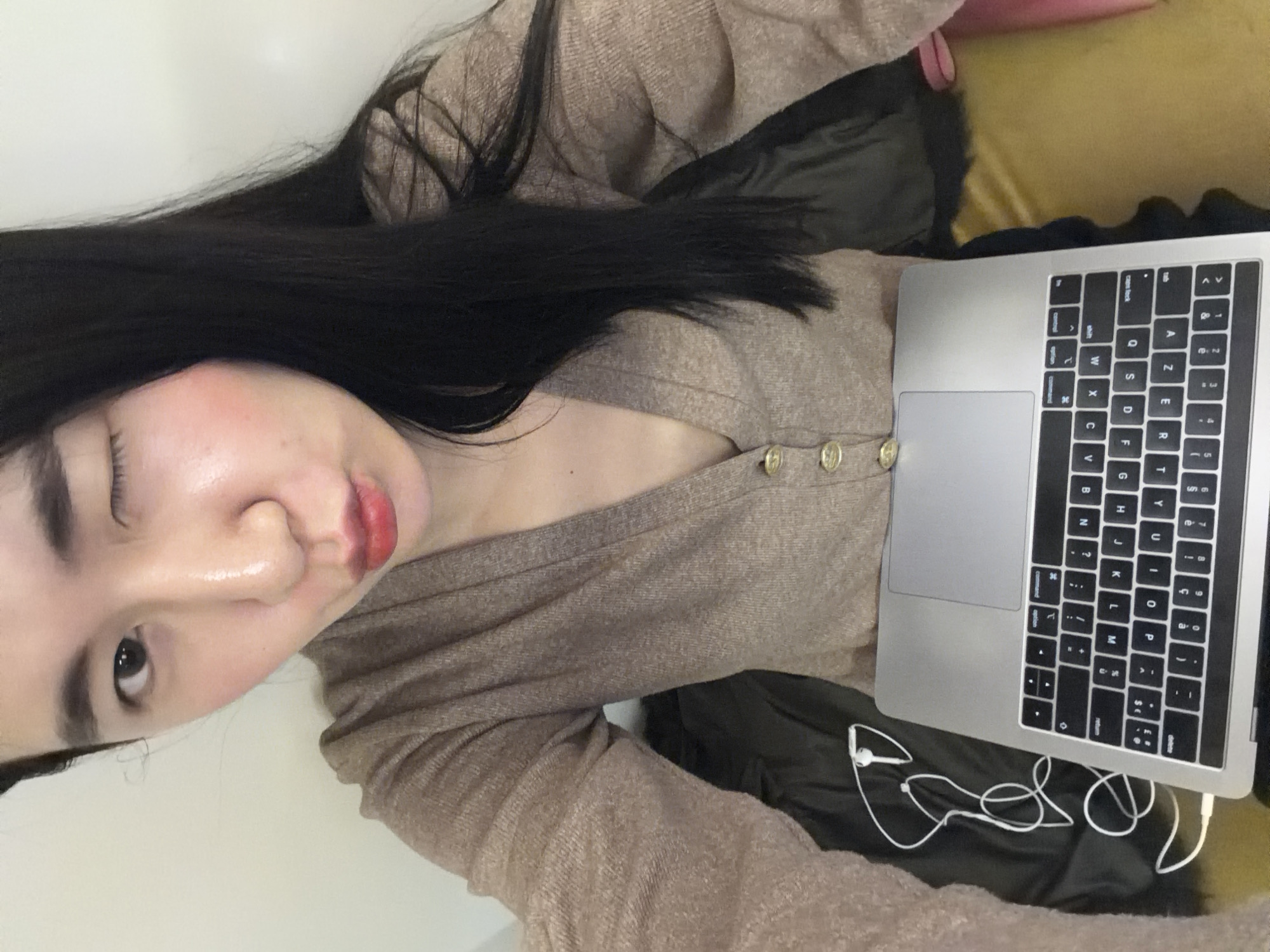 Person with laptop rests on cushioned surface in Paris