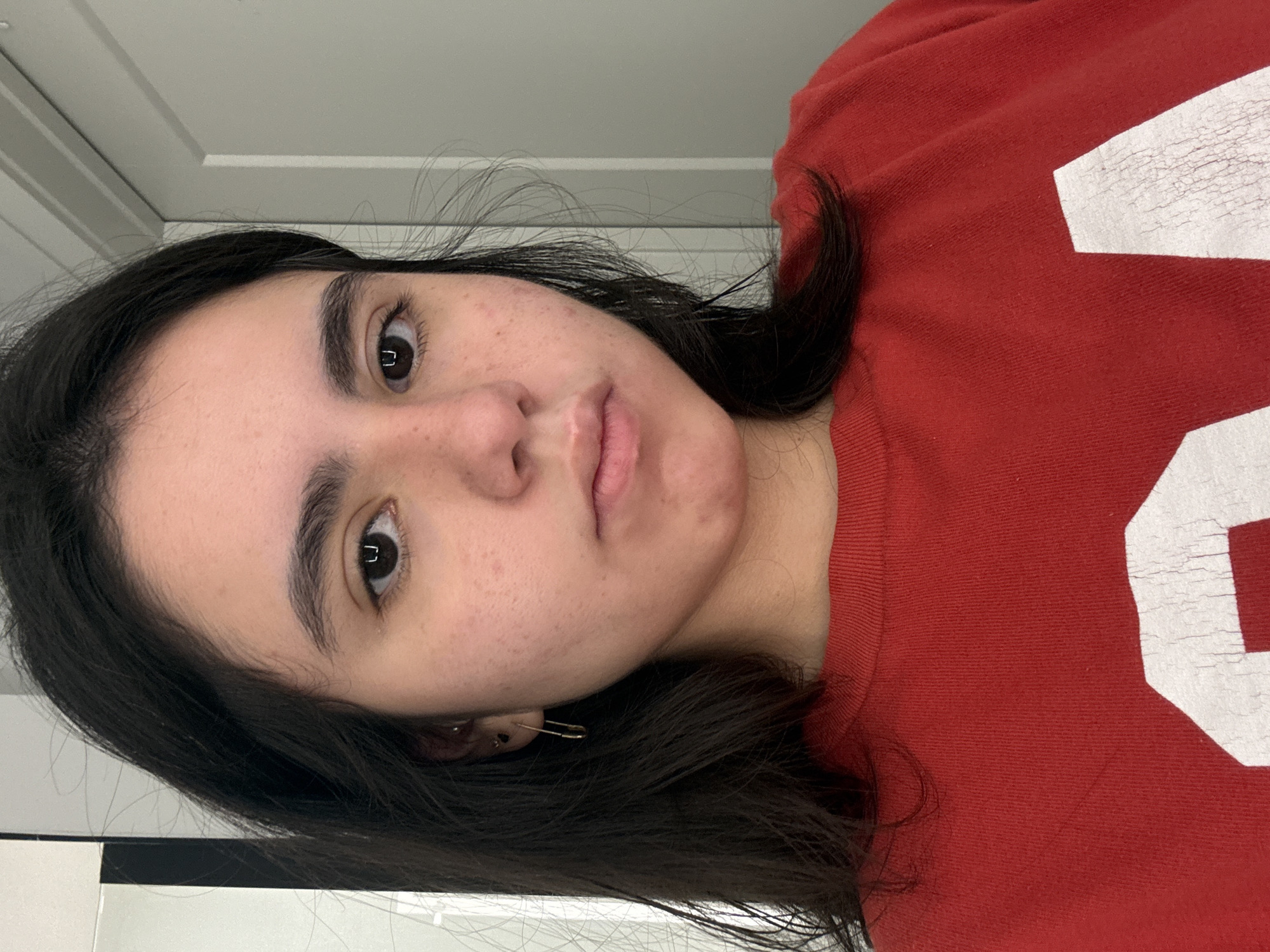Woman in red shirt photographed indoors in Austin