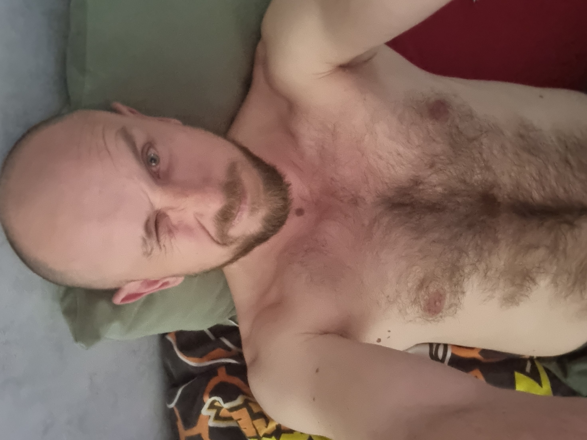 Two people rest on bed in Sochi apartment