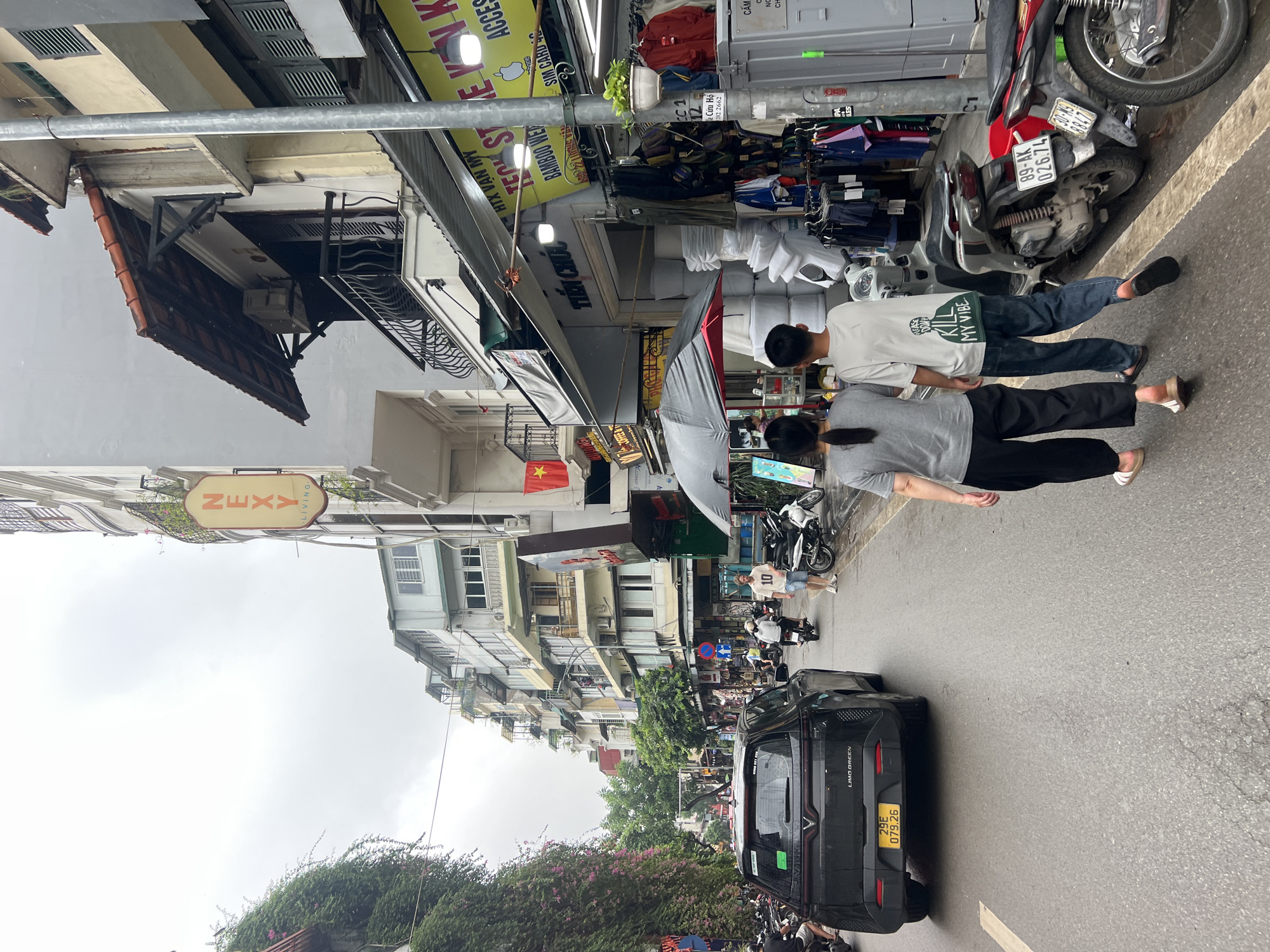 Cyclopousse and market stalls on a Hanoi street