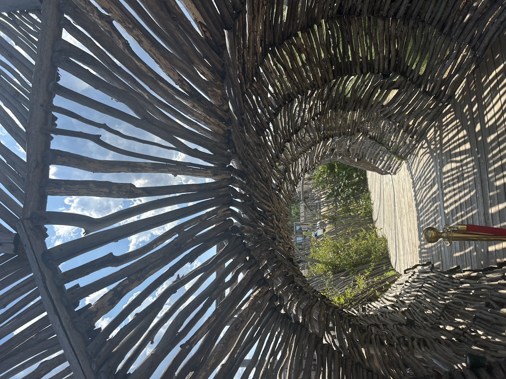 Woven branch tunnel leads to a wooden boardwalk in Sozopol