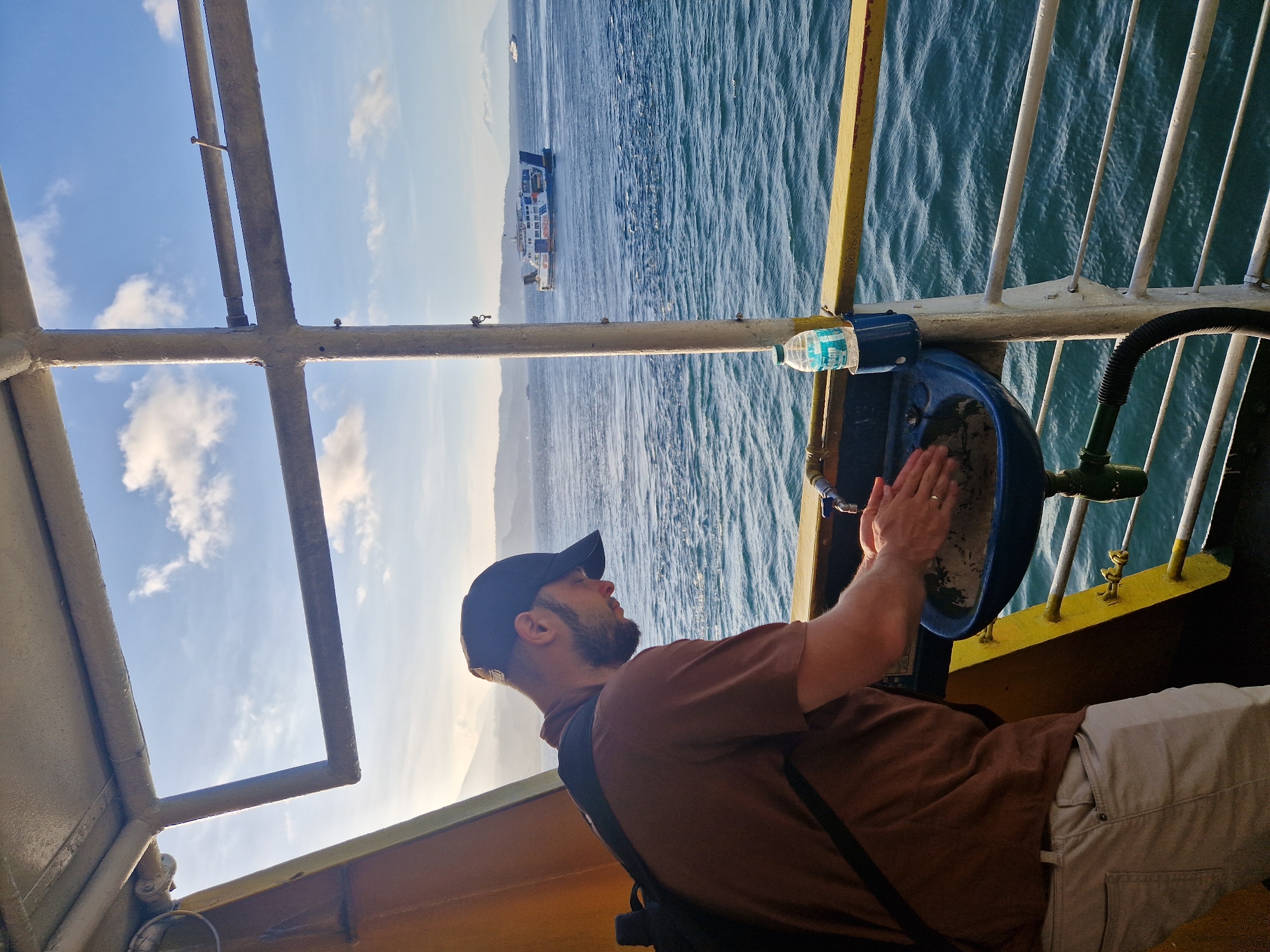 Ferry passengers document morning journey near Melaya, Indonesia coastline