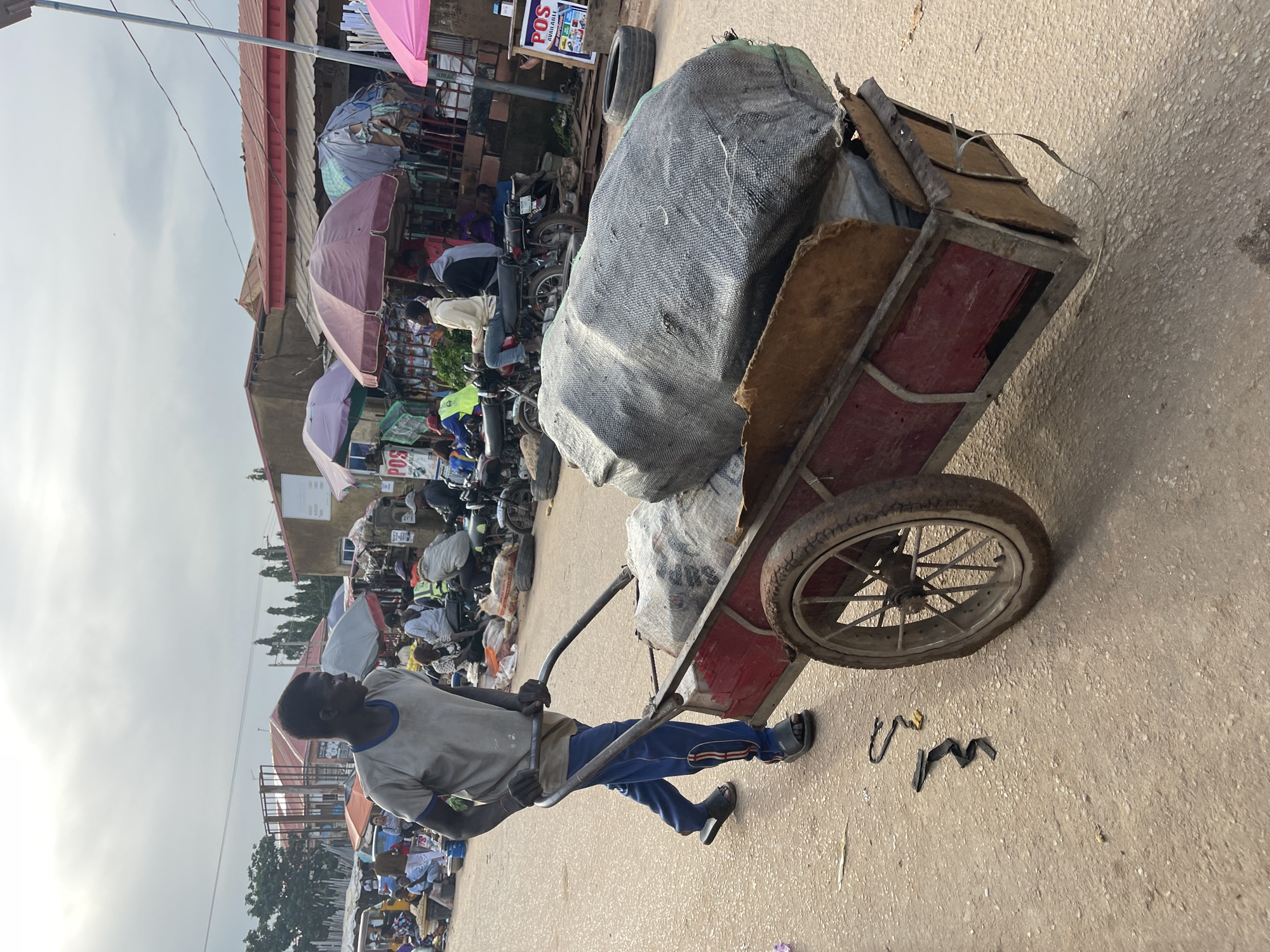 Abuja street market buzzing with vendors, carts, and trade