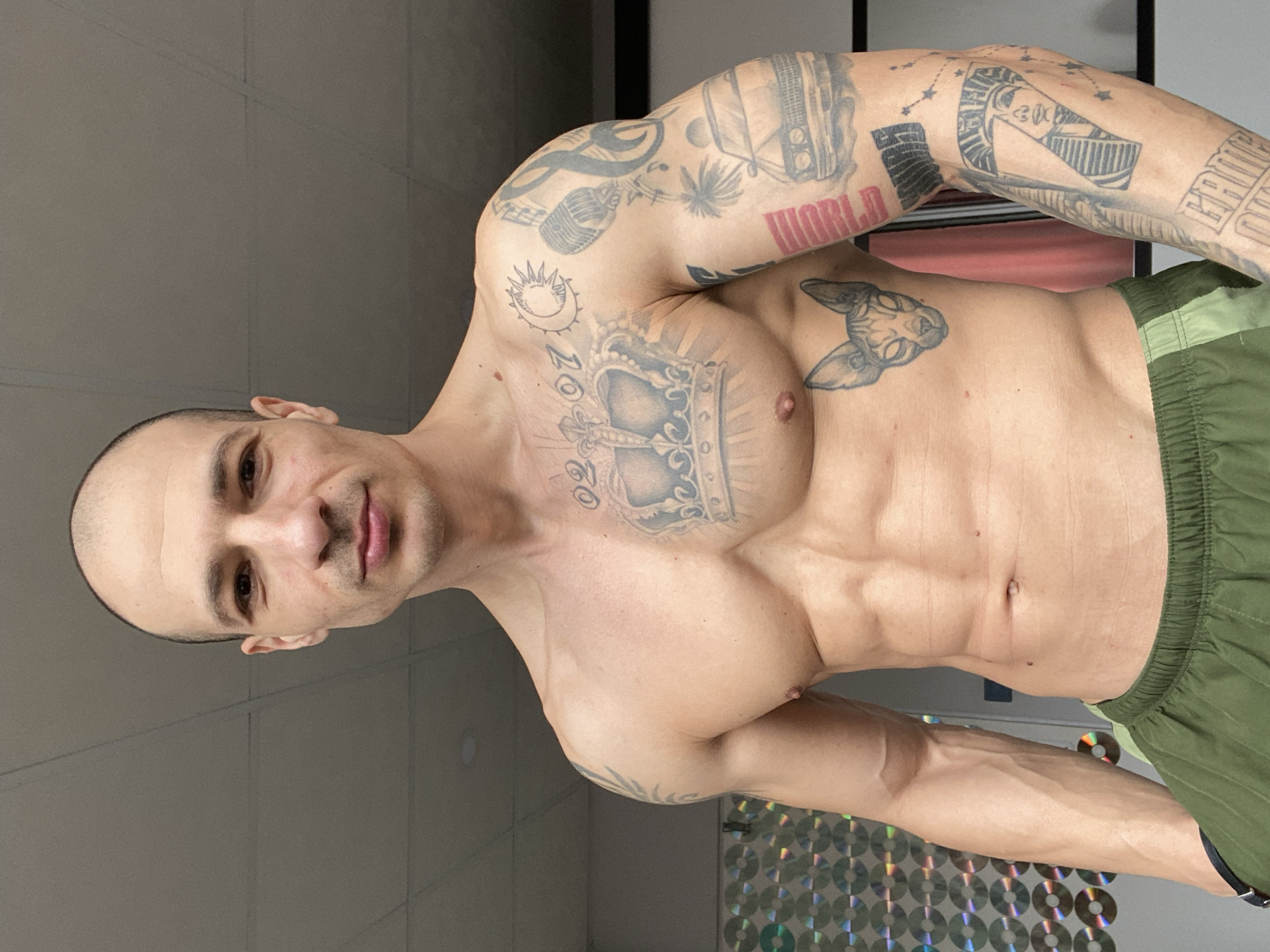 Tattooed man documents selfie session in Bulgarian home