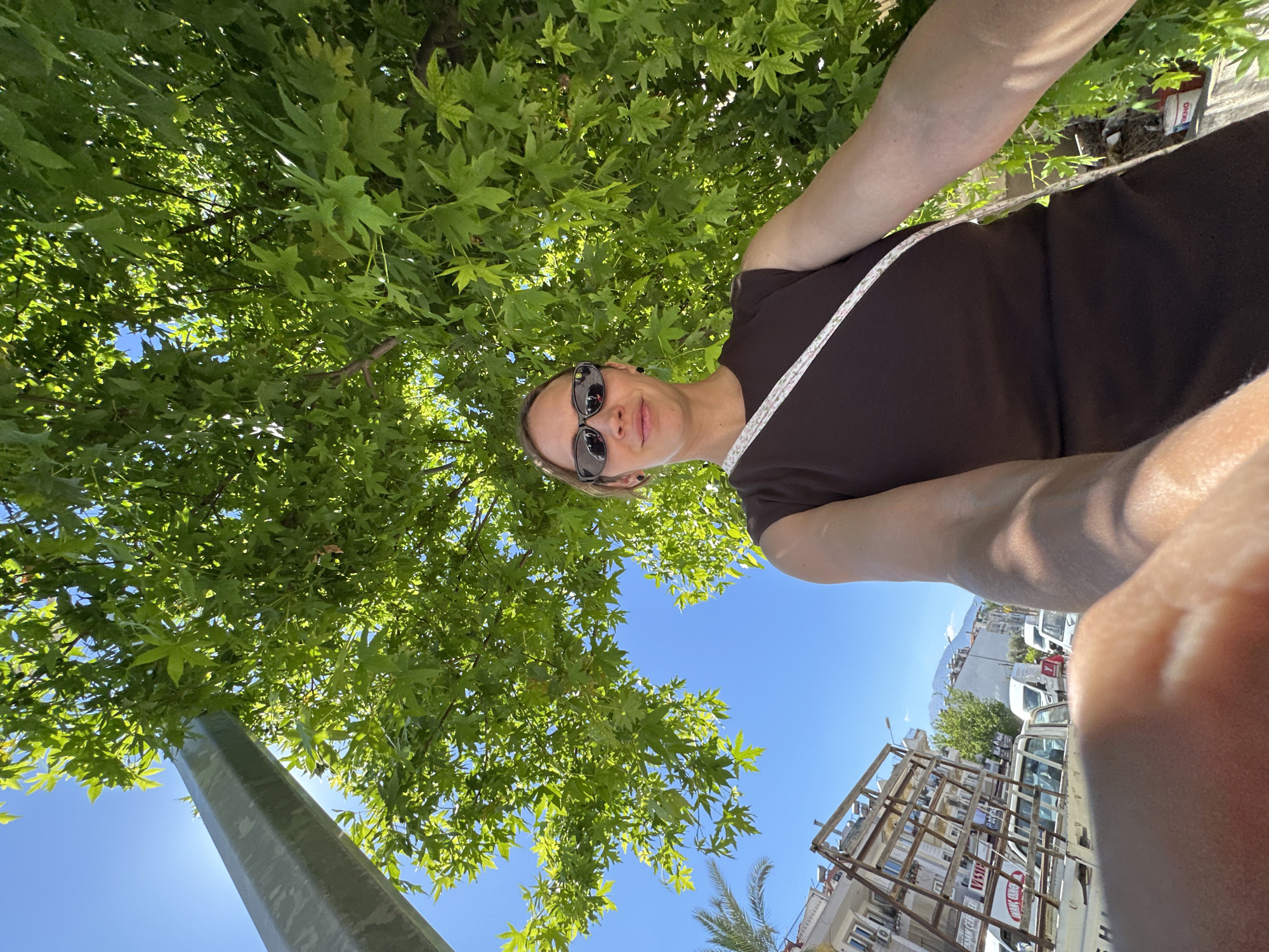 Woman takes selfie under tree in Fethiye, Turkey