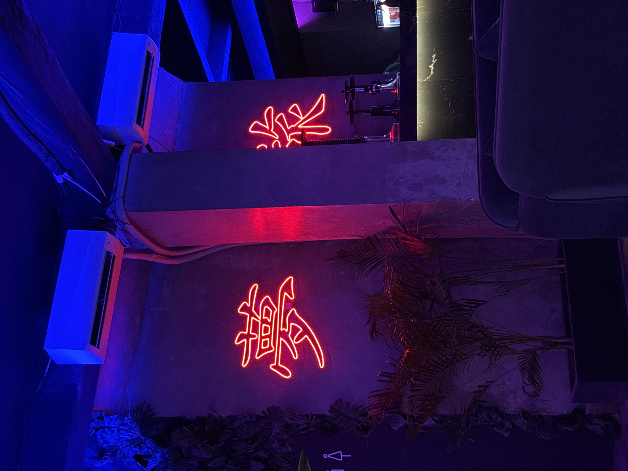 Bar patron documents neon-lit lounge with hookah in Kuta Selatan