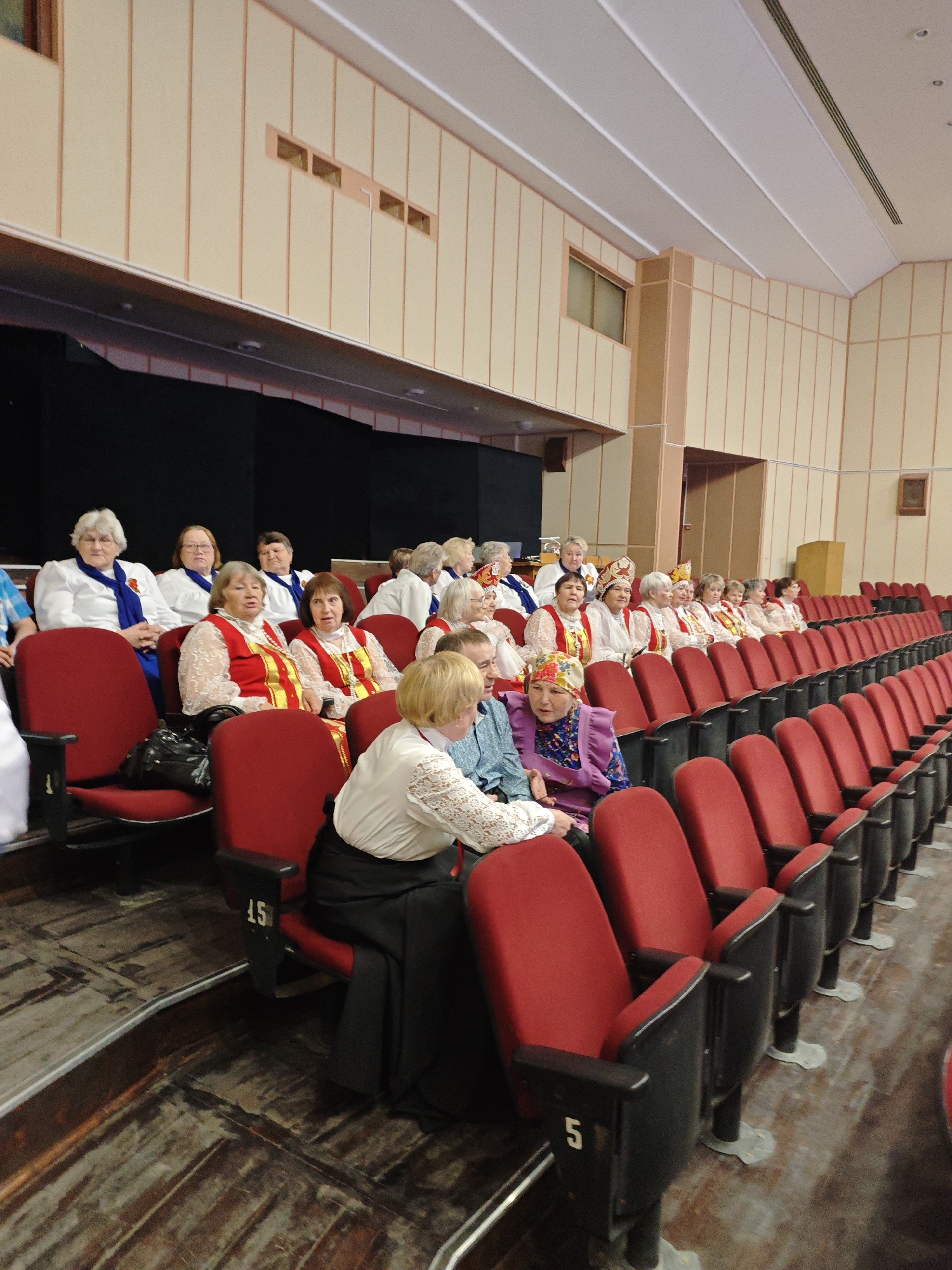 Women in traditional Russian folk costumes gather in Markovskii auditorium