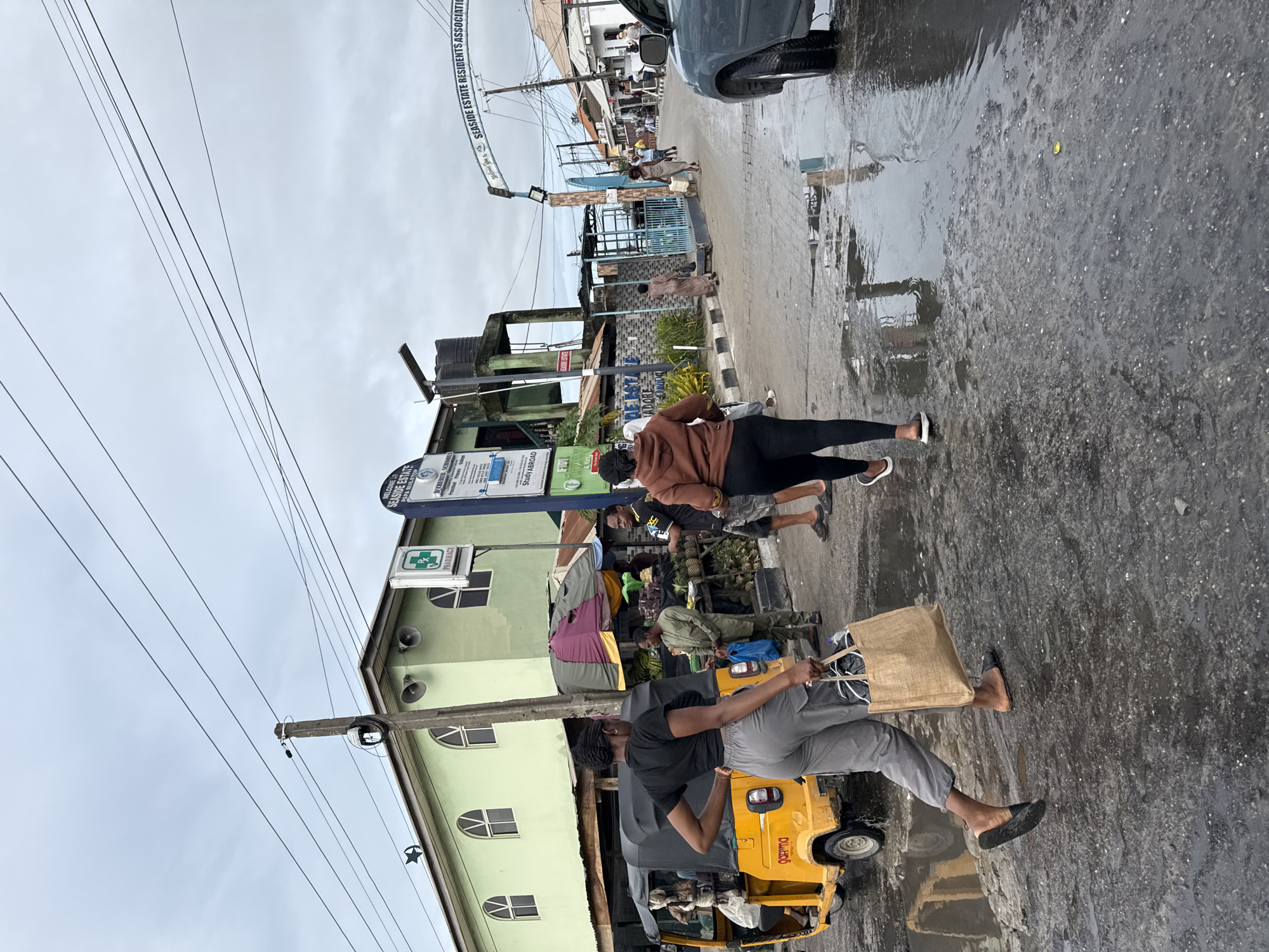 Pedestrians walk wet streets in Ado after rain