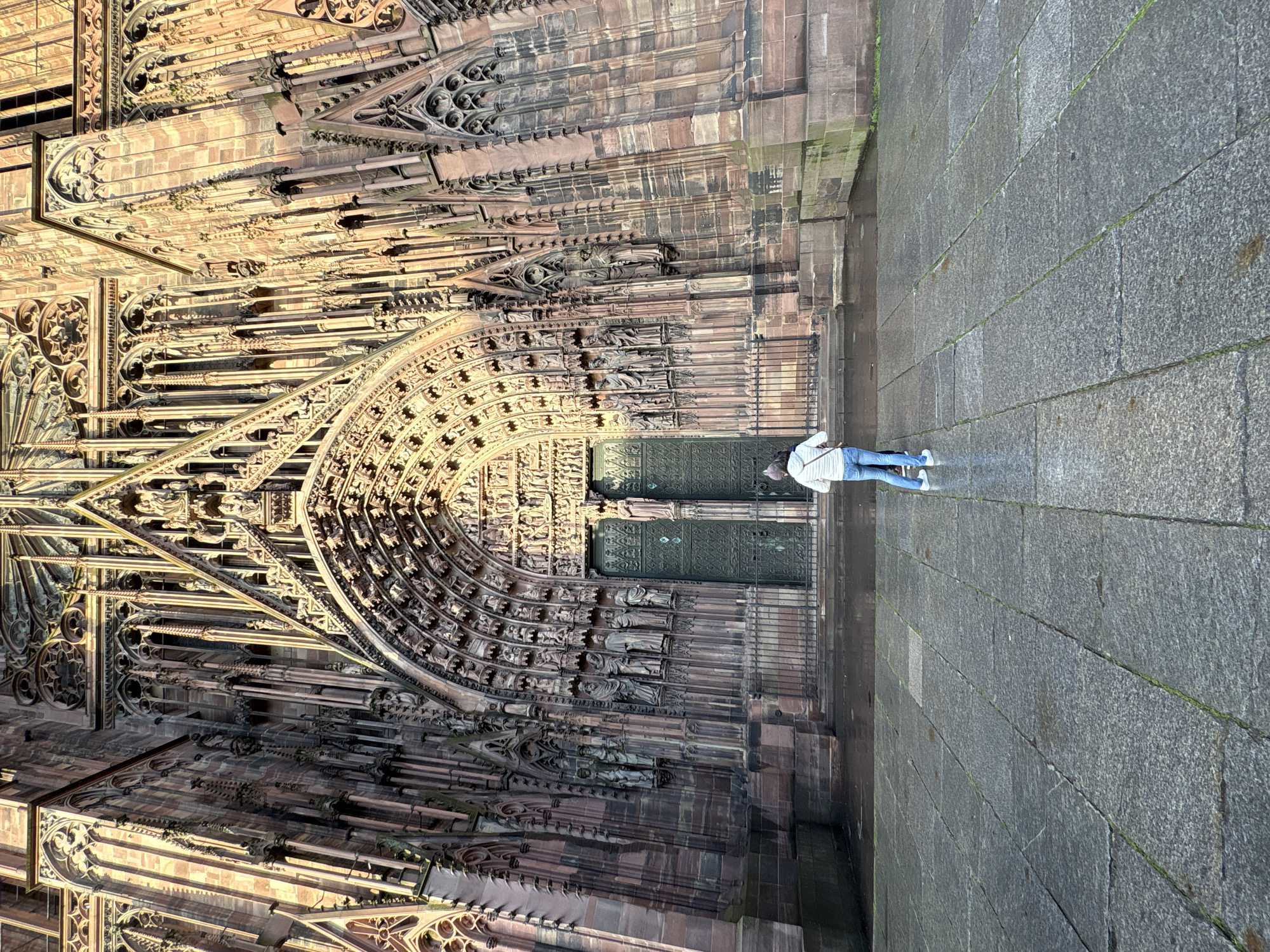 Tourist documents Strasbourg Cathedral during rainy evening visit