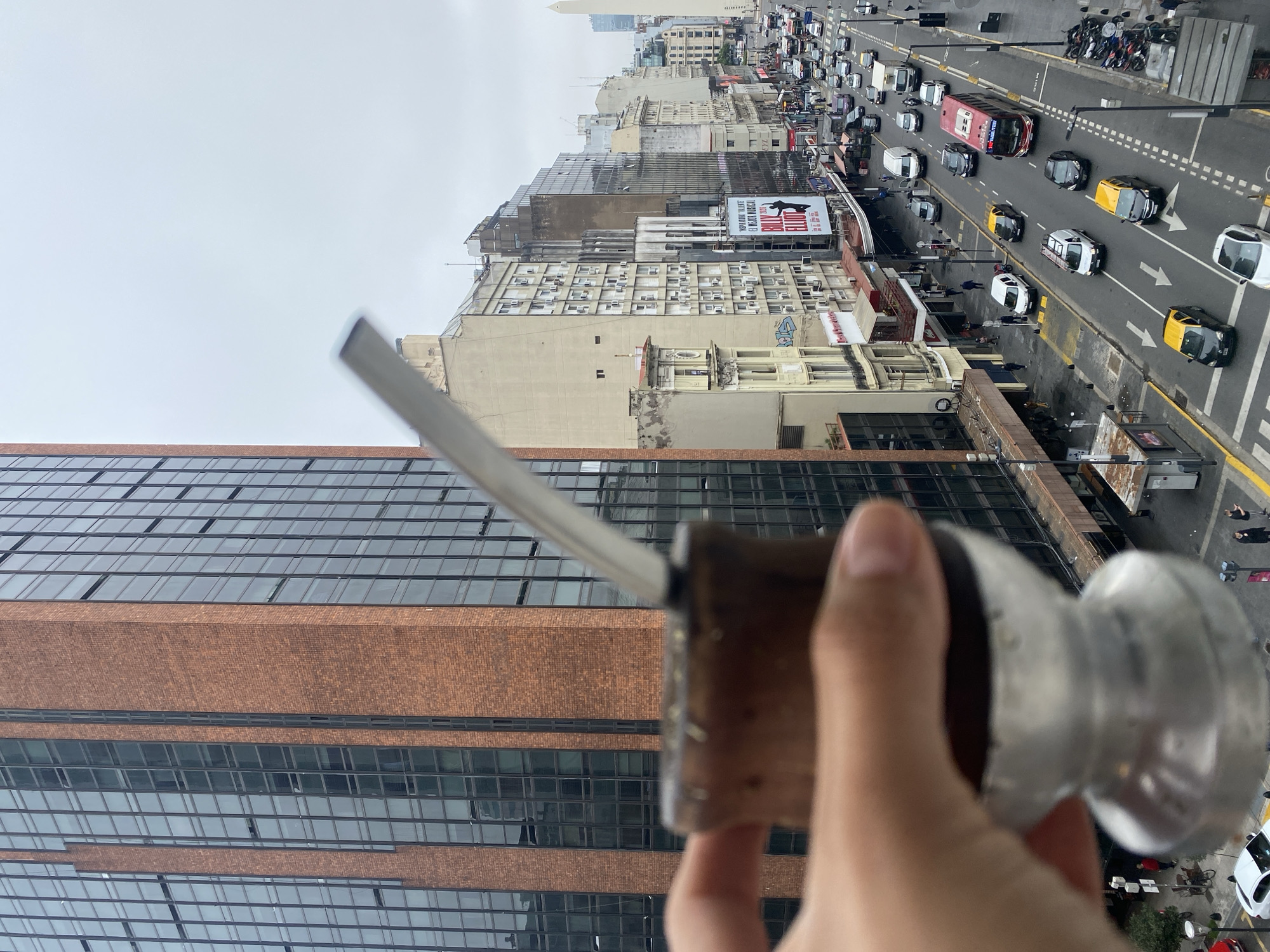 Person enjoys traditional mate with Buenos Aires cityscape view