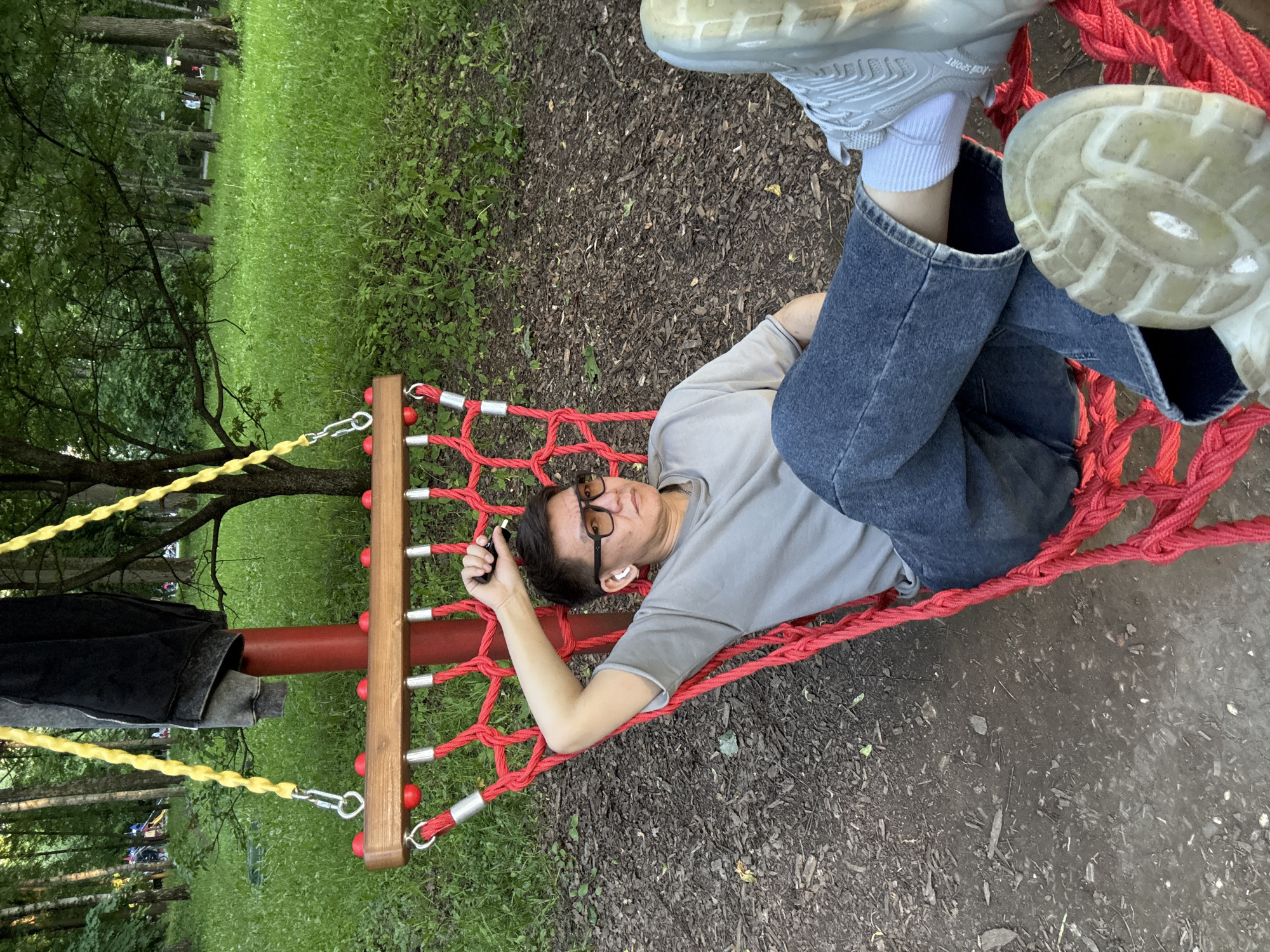 Man relaxes in red hammock at Moscow park