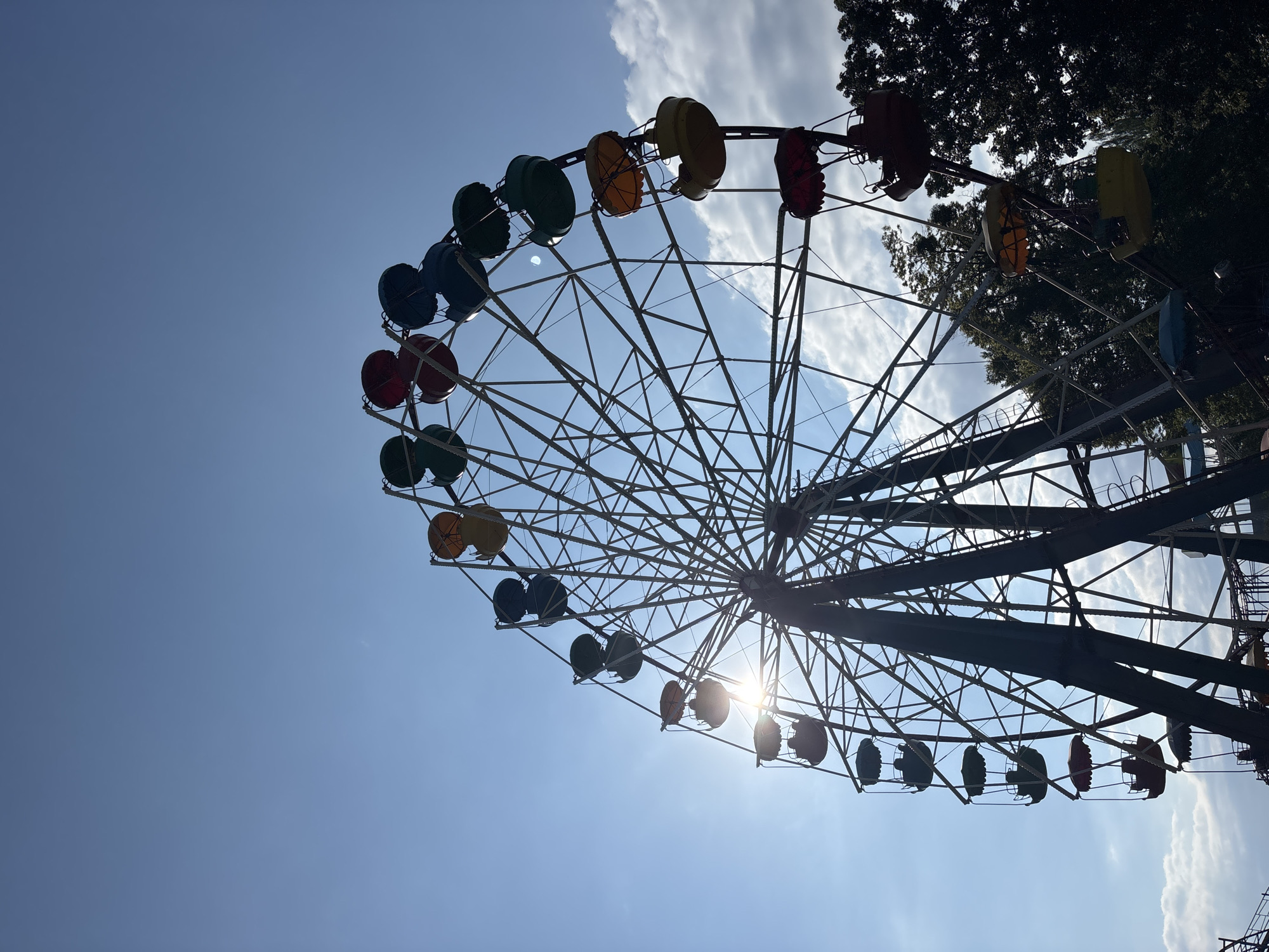 Morning at a fairground park, flowers and rides in the sun