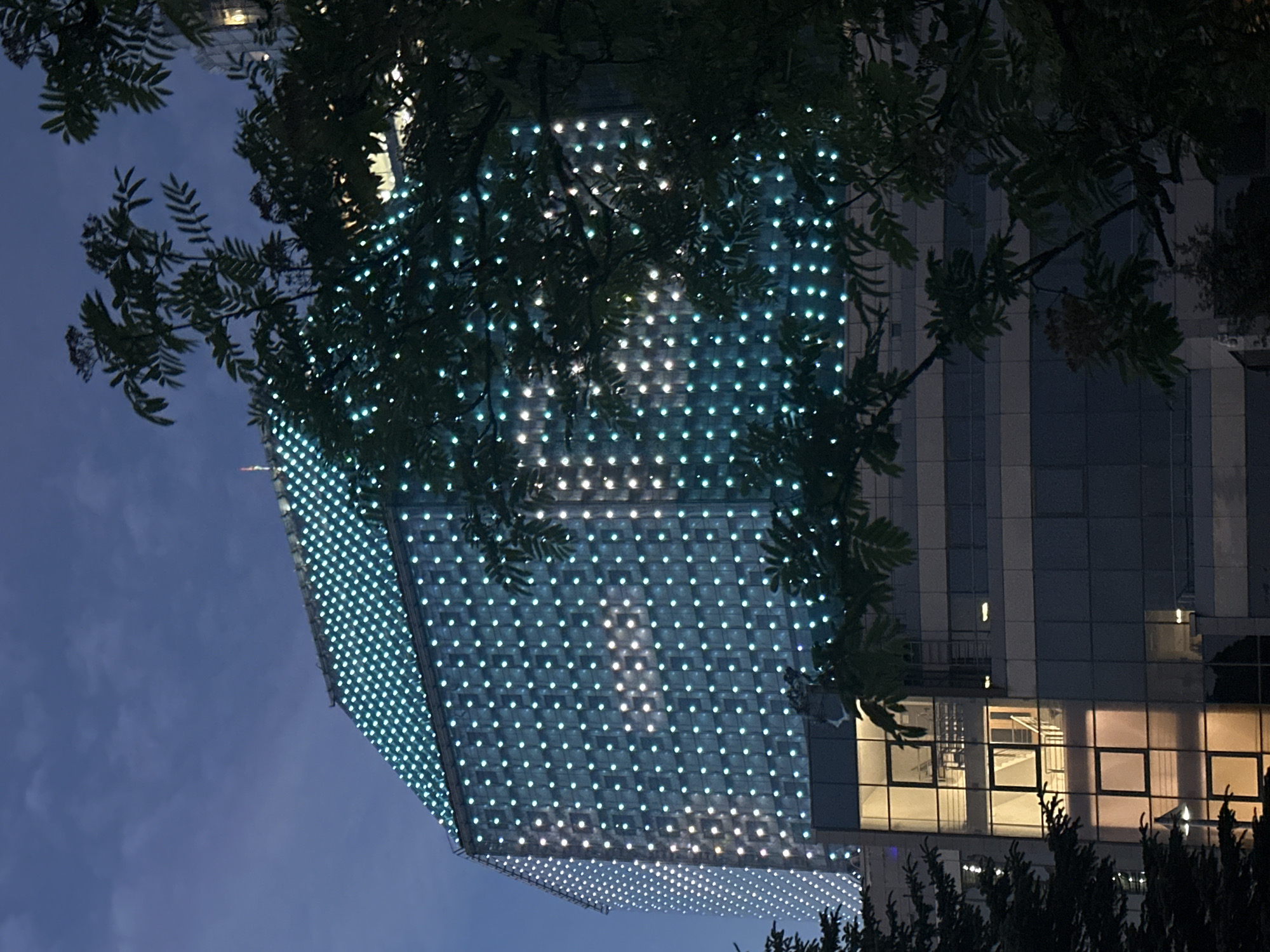 Illuminated modern building observed at dusk in Minsk