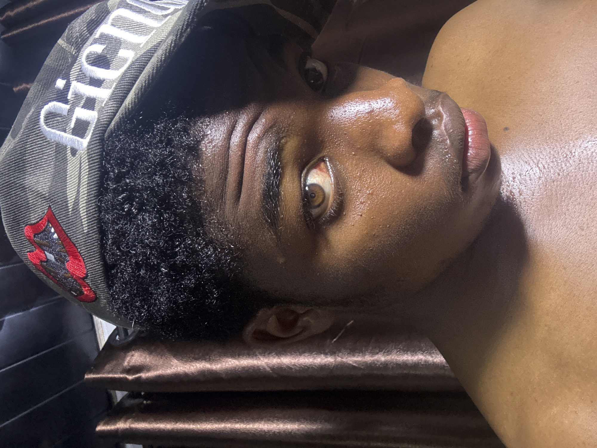 Person photographed resting with camouflage cap in Bukuru, Nigeria