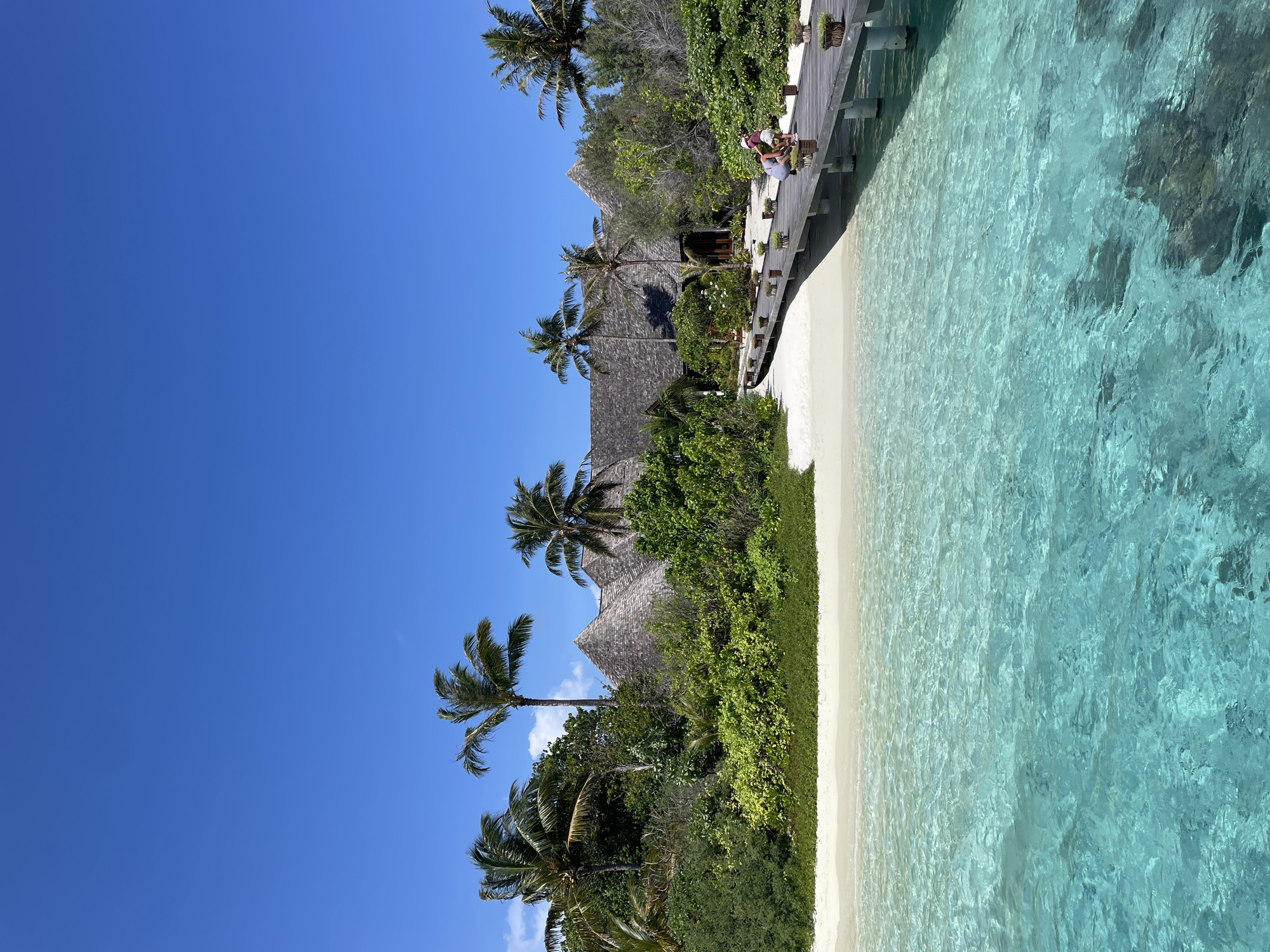 White sand beach with turquoise water and a resort building behind