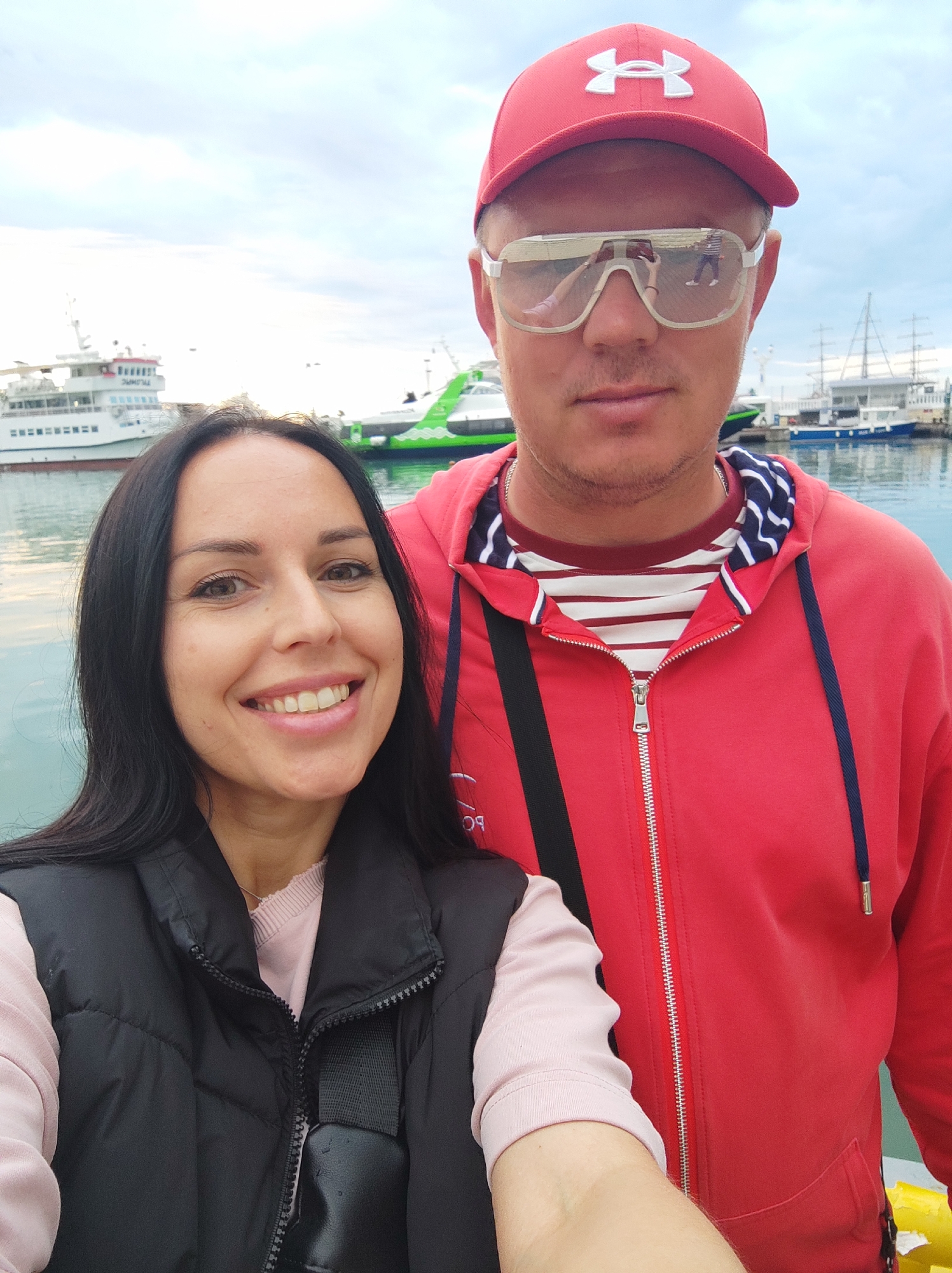 Tourists document typical afternoon scenes at Sochi harbor waterfront