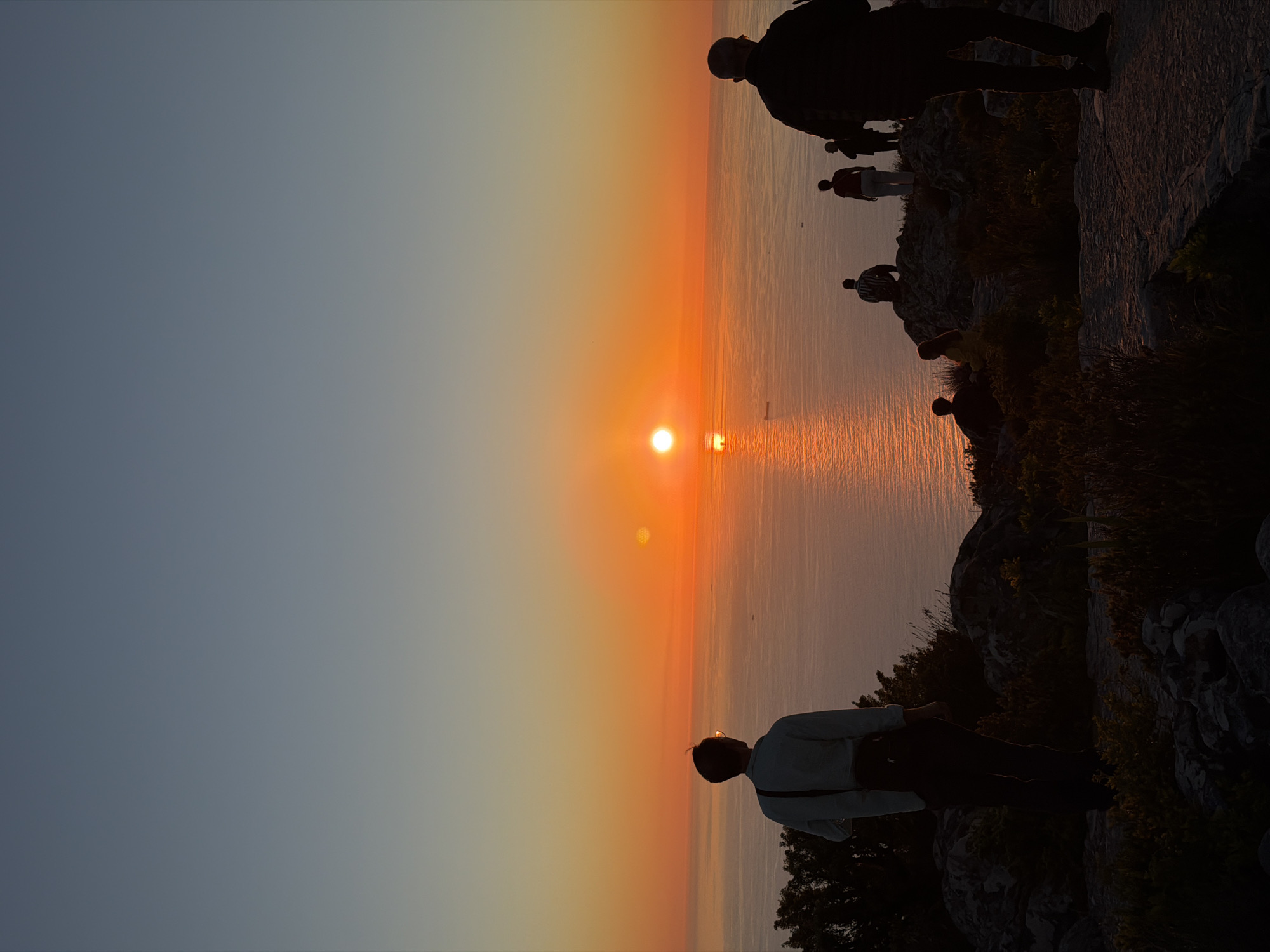 Cape Town coastal sunset draws observers to rocky outcrops