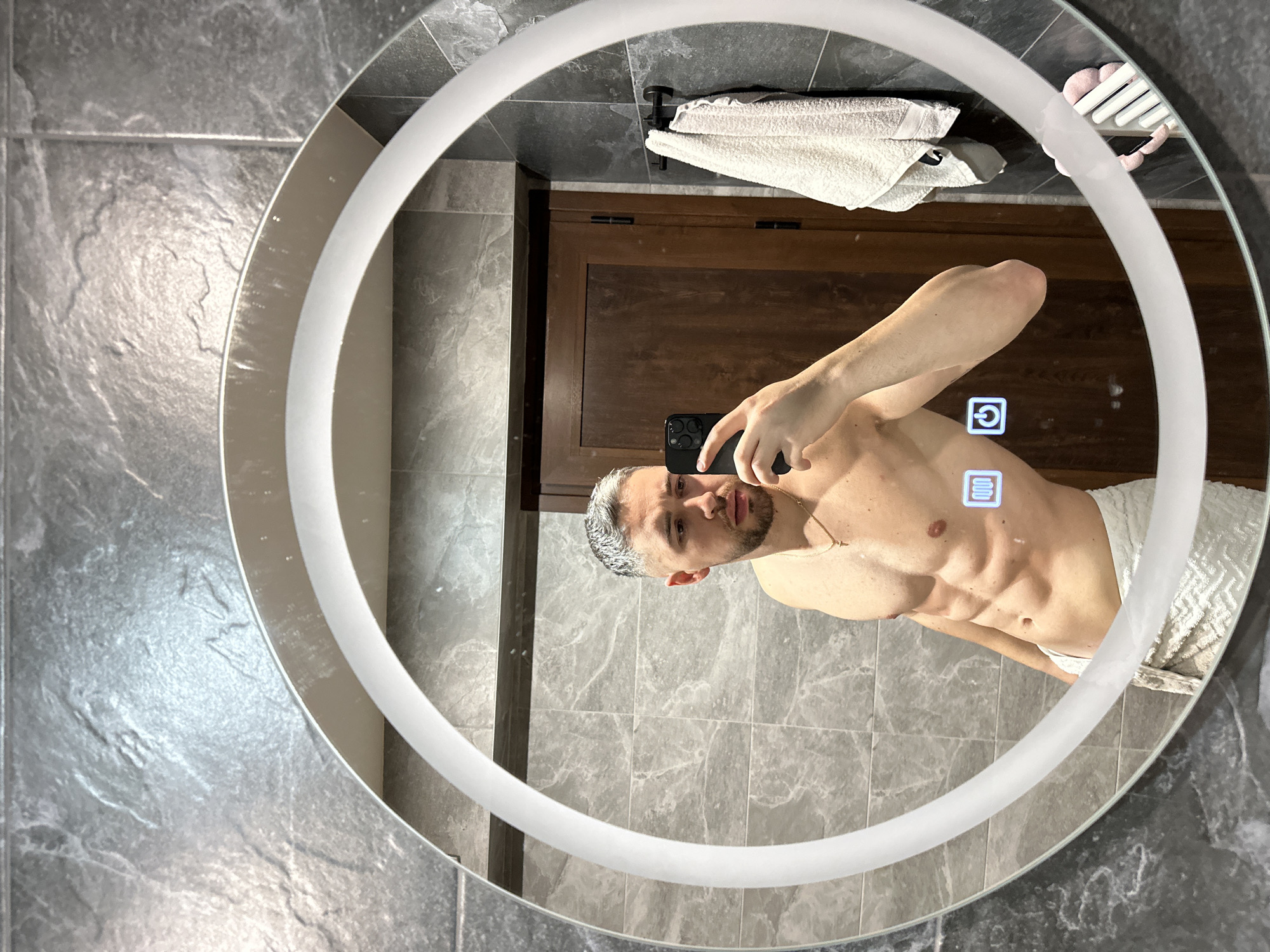 Man Takes Bathroom Mirror Selfie in Gray Tiled Modern Bathroom