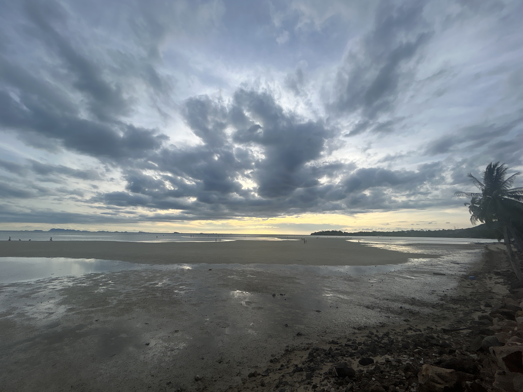 Evening beachgoers enjoy dramatic low tide at Koh Phangan