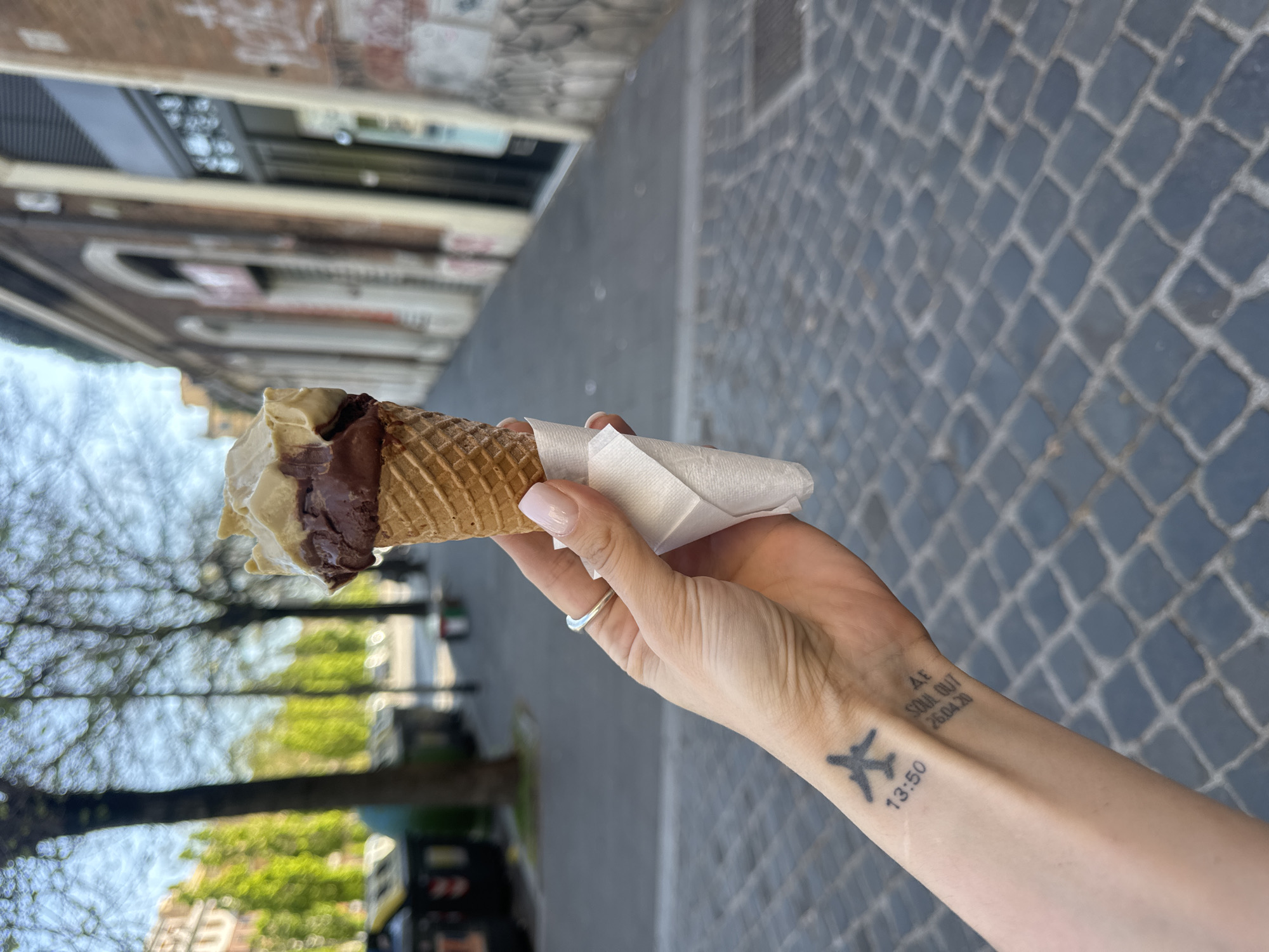 Woman enjoys gelato on cobblestone street in Rome