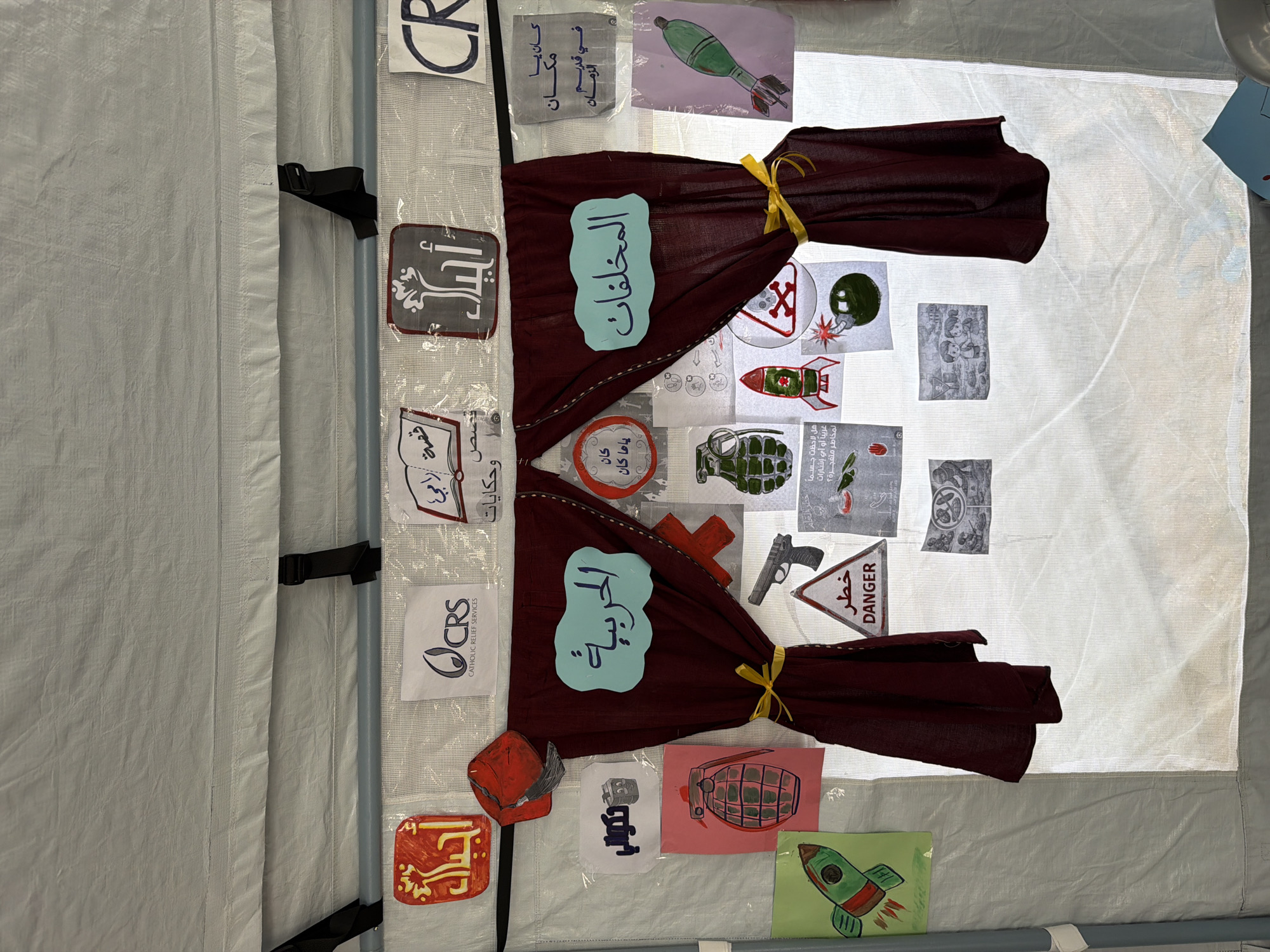 Handmade conflict-themed drawings displayed in Gaza temporary structure