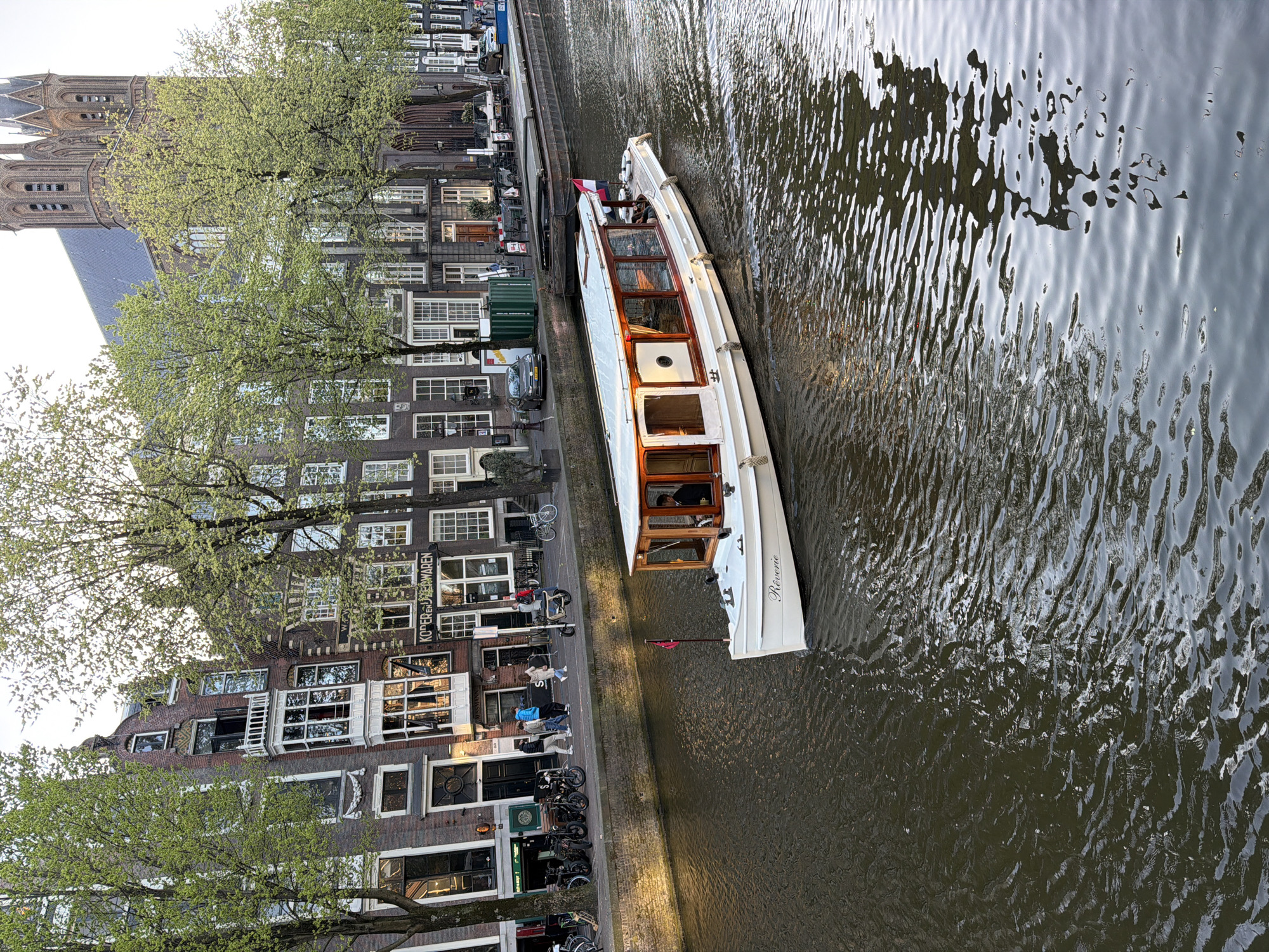 Tourist boats with tulip displays navigate Amsterdam canals