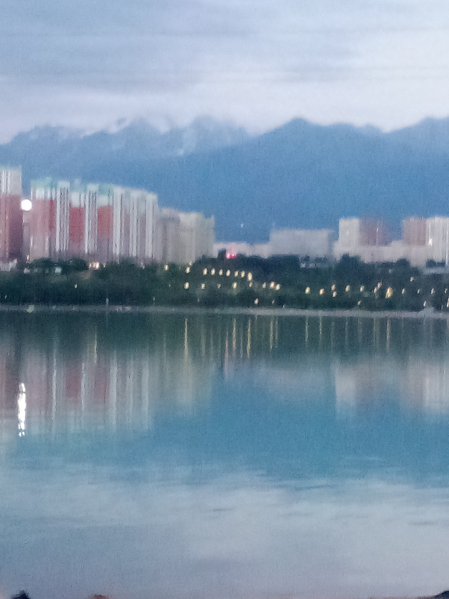 Almaty lakeside promenade under cloudy skies, late afternoon