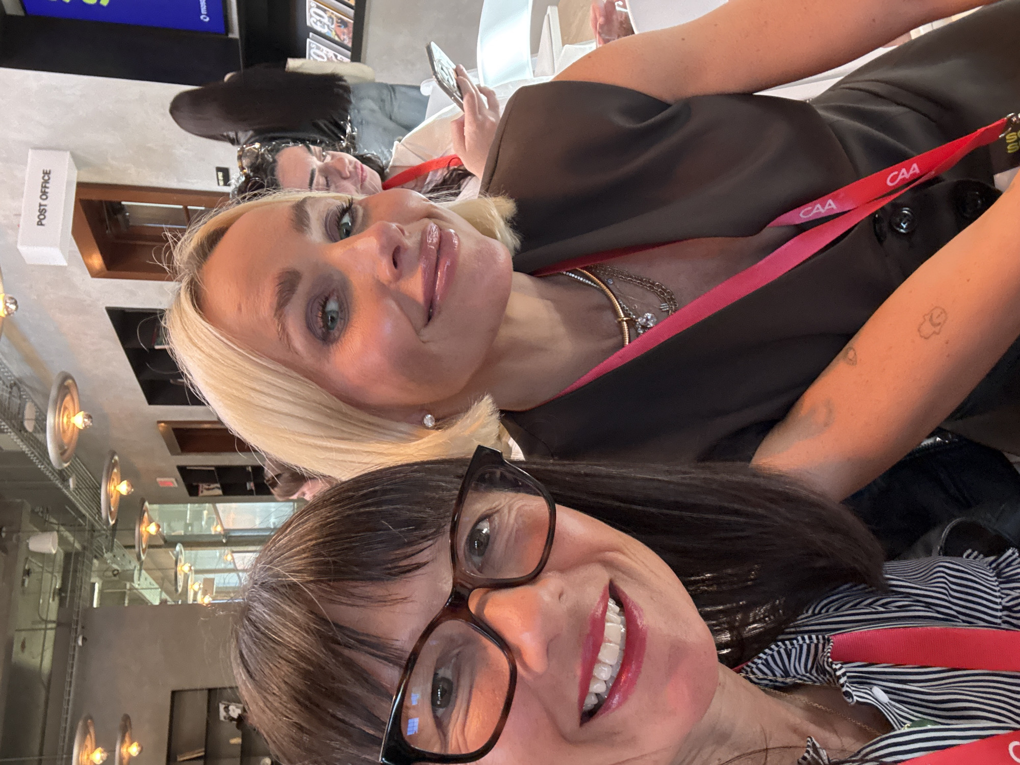 Two women take smiling selfie indoors