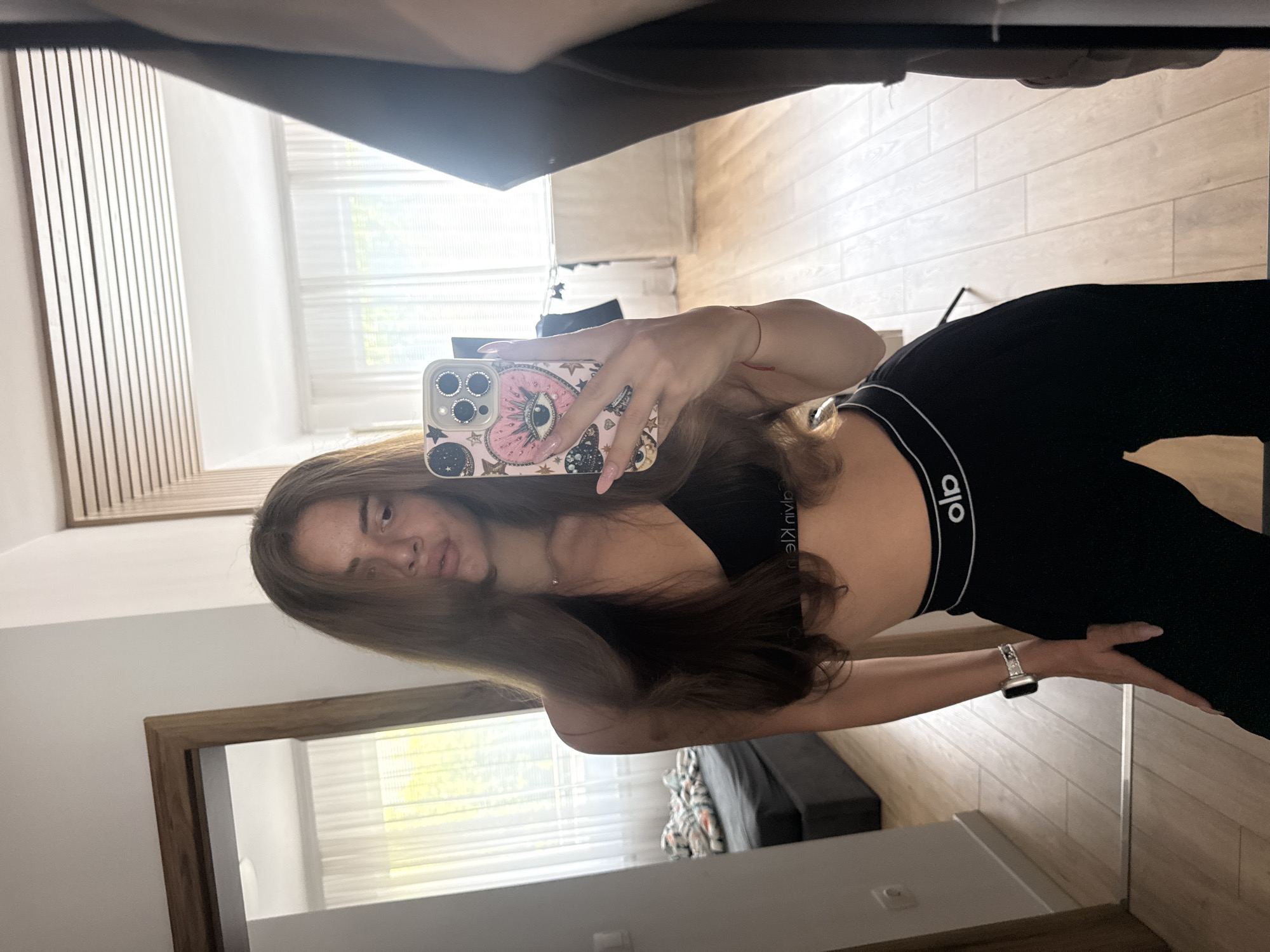 Woman takes mirror selfie in Calvin Klein sportswear